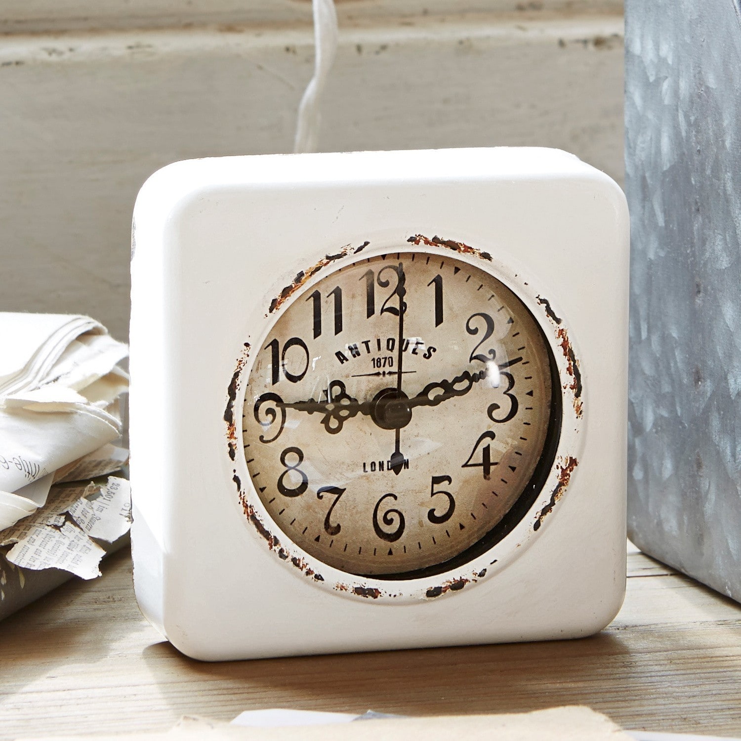 Klok Gervase Witte tafelklok met verouderde wijzerplaat en zwarte cijfers, vintage interieurdecoratie.