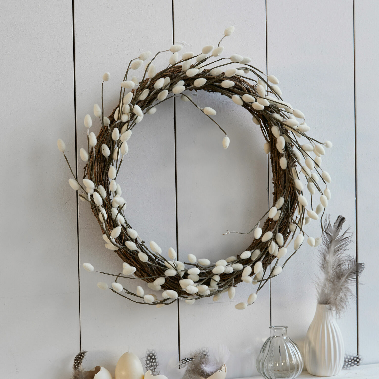 Couronne Prapante Couronne décorative en branches avec bourgeons blancs duveteux sur mur clair, décoration printanière