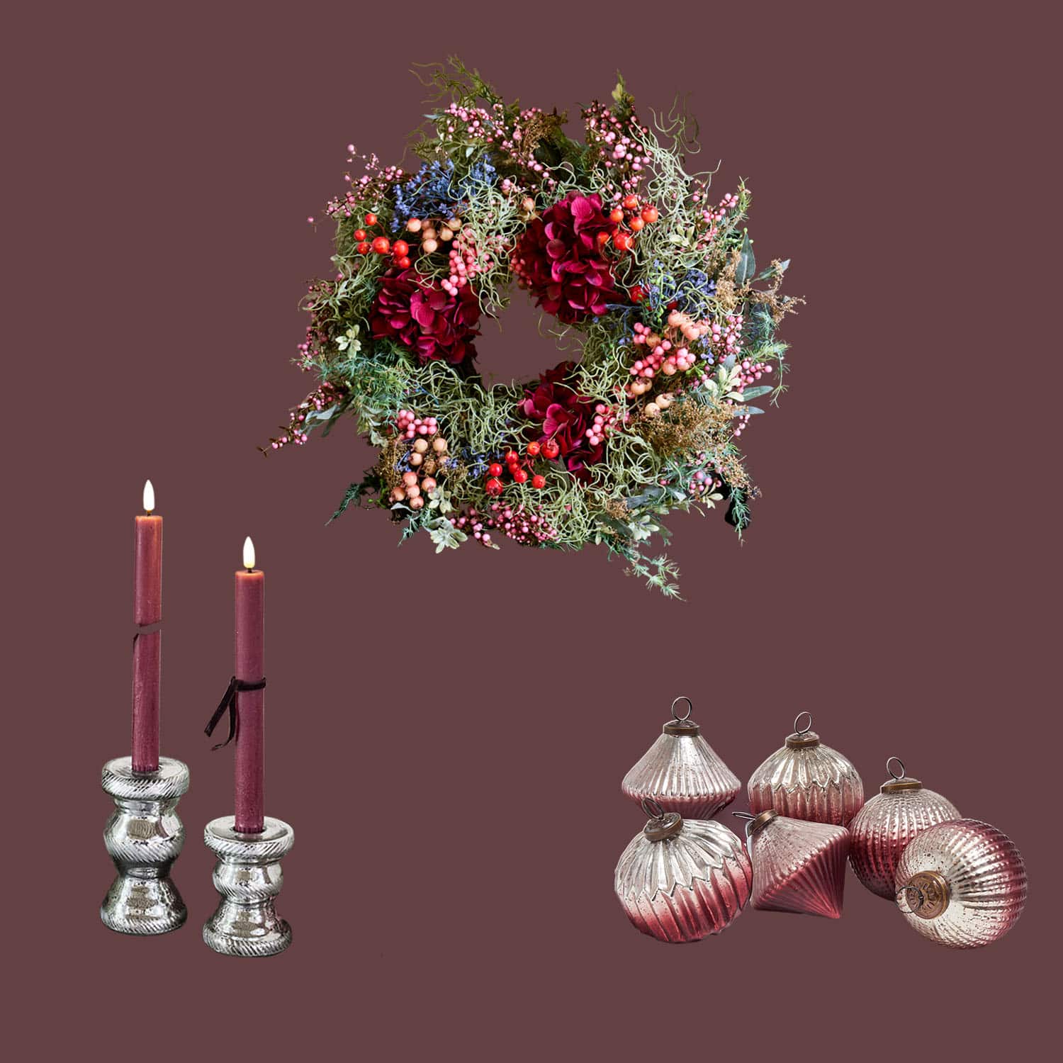 Decoratieve krans met rode bloemen en bessen, bordeauxrode kaarsen in zilveren kandelaars, kerstversiering