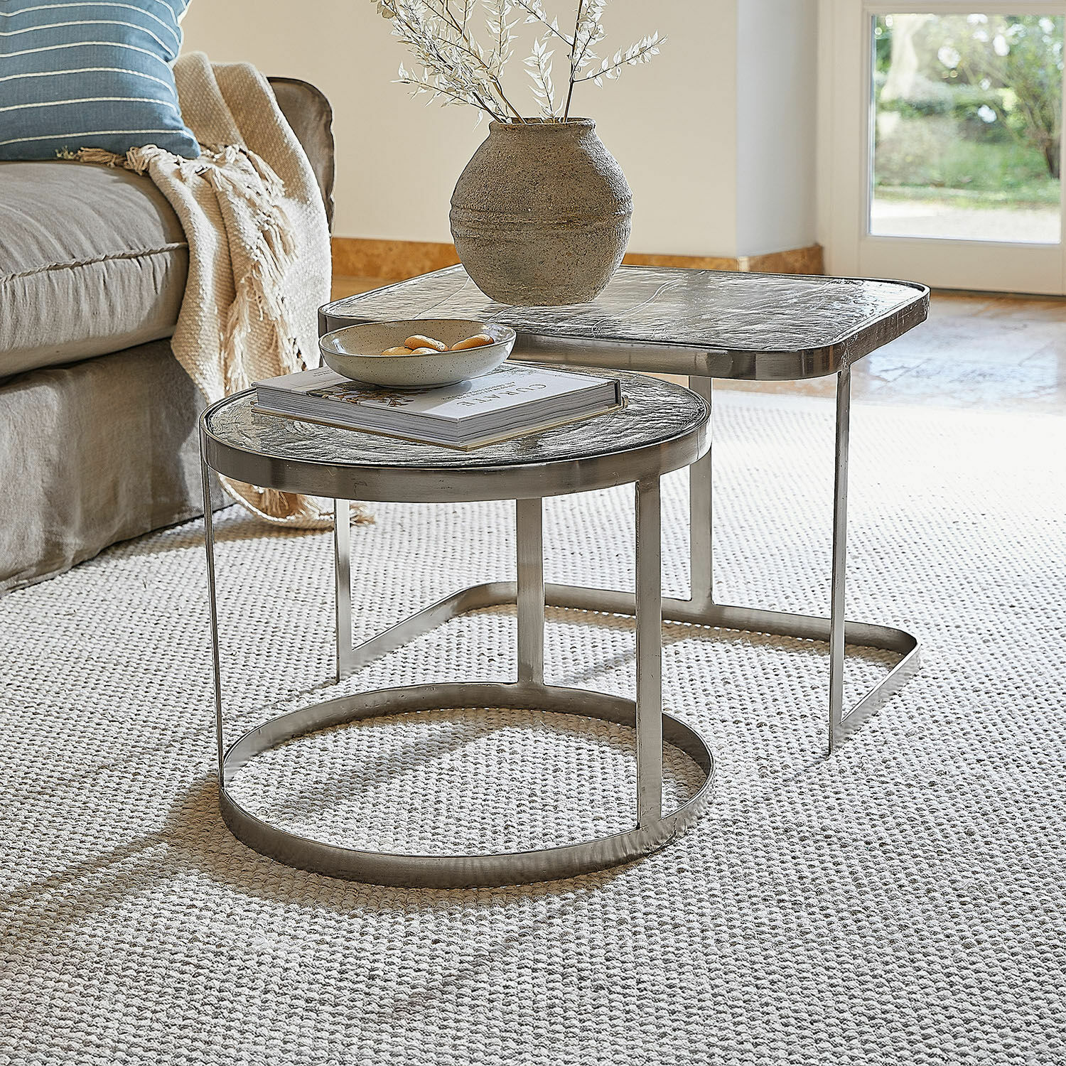 Salontafel set van 2 Yvelissel Set van twee salontafels met glazen blad en zilverkleurig metalen frame op lichte vloerbedekking