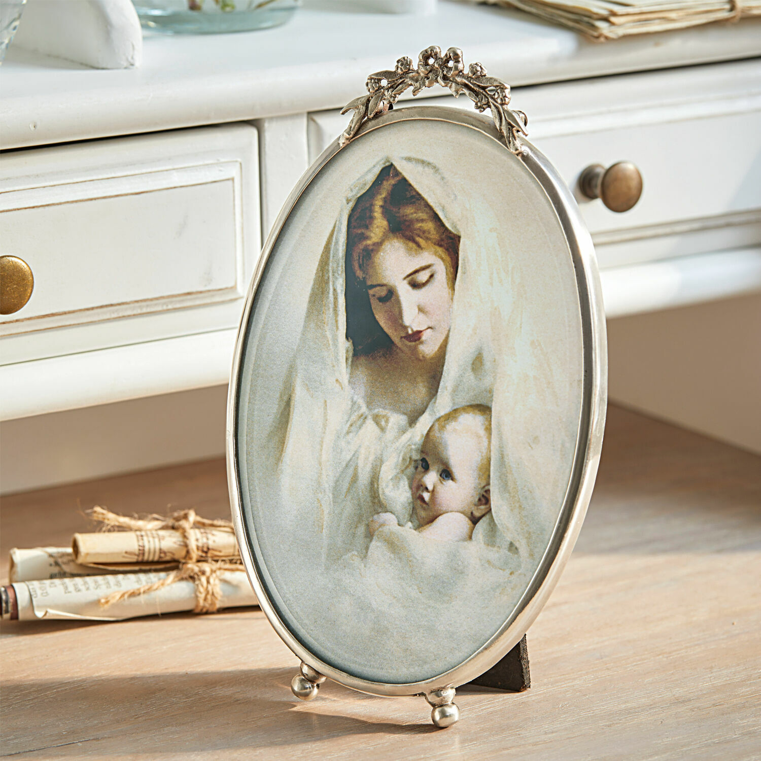 Fotolijstje Grange Ovale metalen lijst met afbeelding van moeder en baby in witte doeken op houten tafel