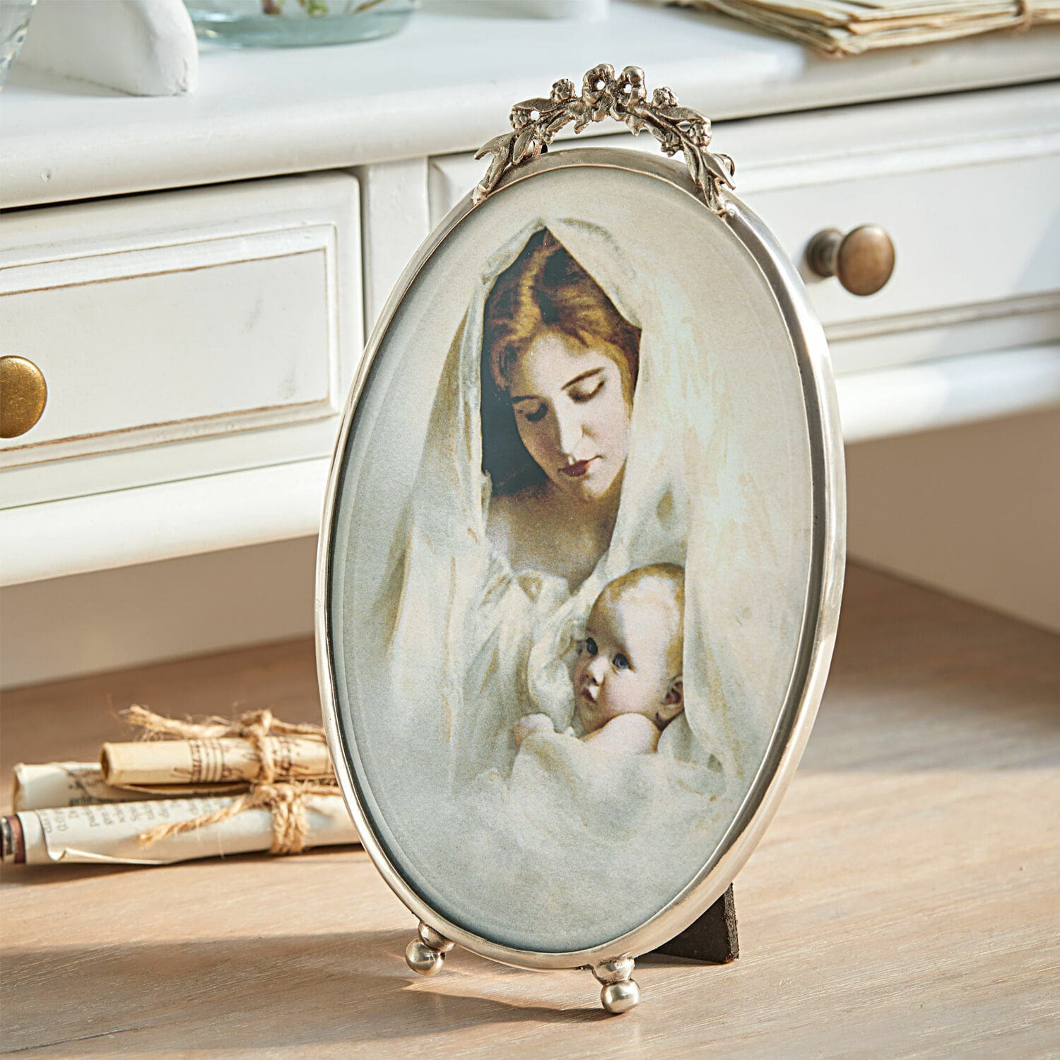 Fotolijstje Grange Ovale metalen lijst met afbeelding van moeder en baby in witte doeken op houten tafel