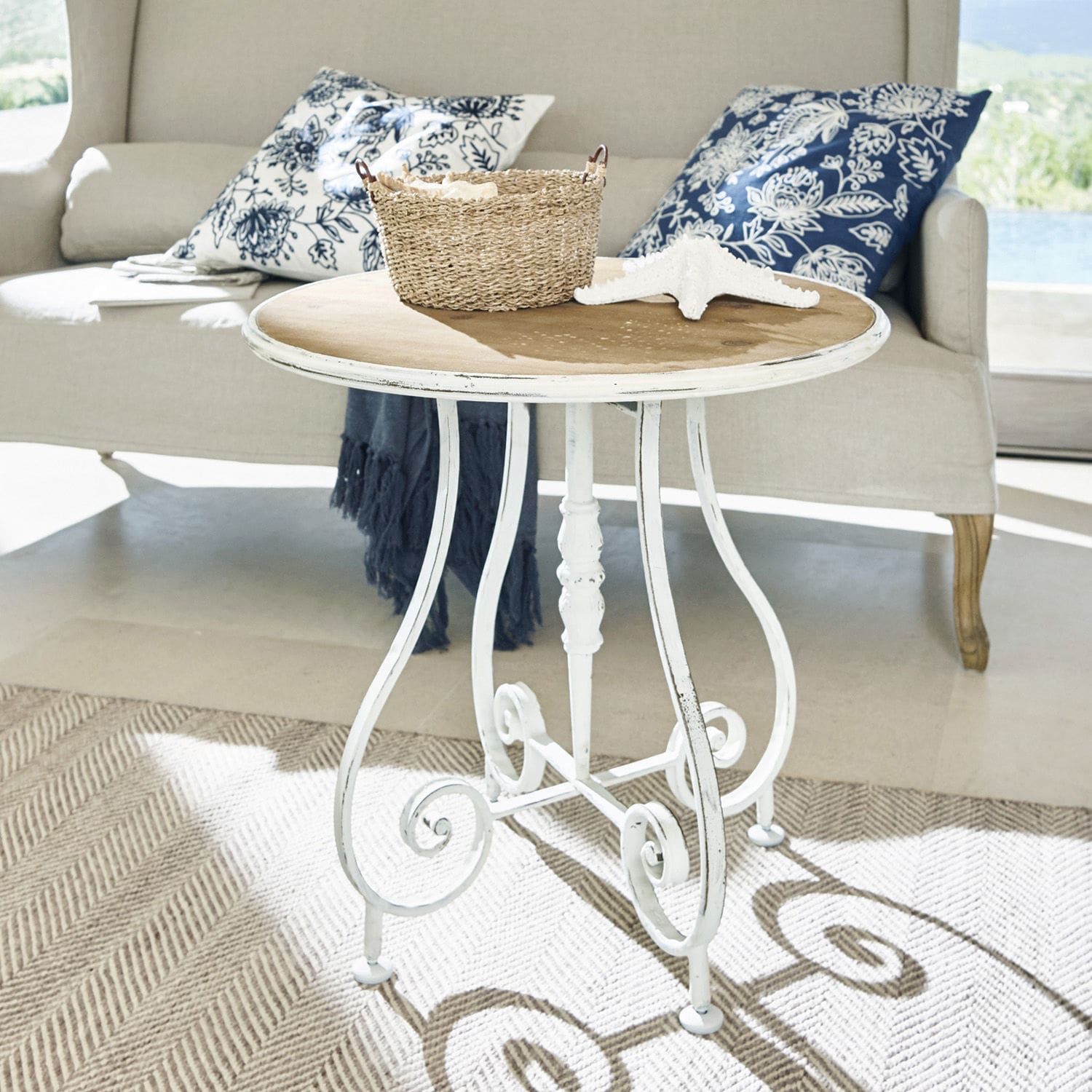 Table ronde avec plateau en bois et base en métal blanc style vintage pour salon lumineux