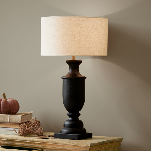 Lampe de table en céramique noire avec abat-jour beige sur une table en bois, décoration intérieure