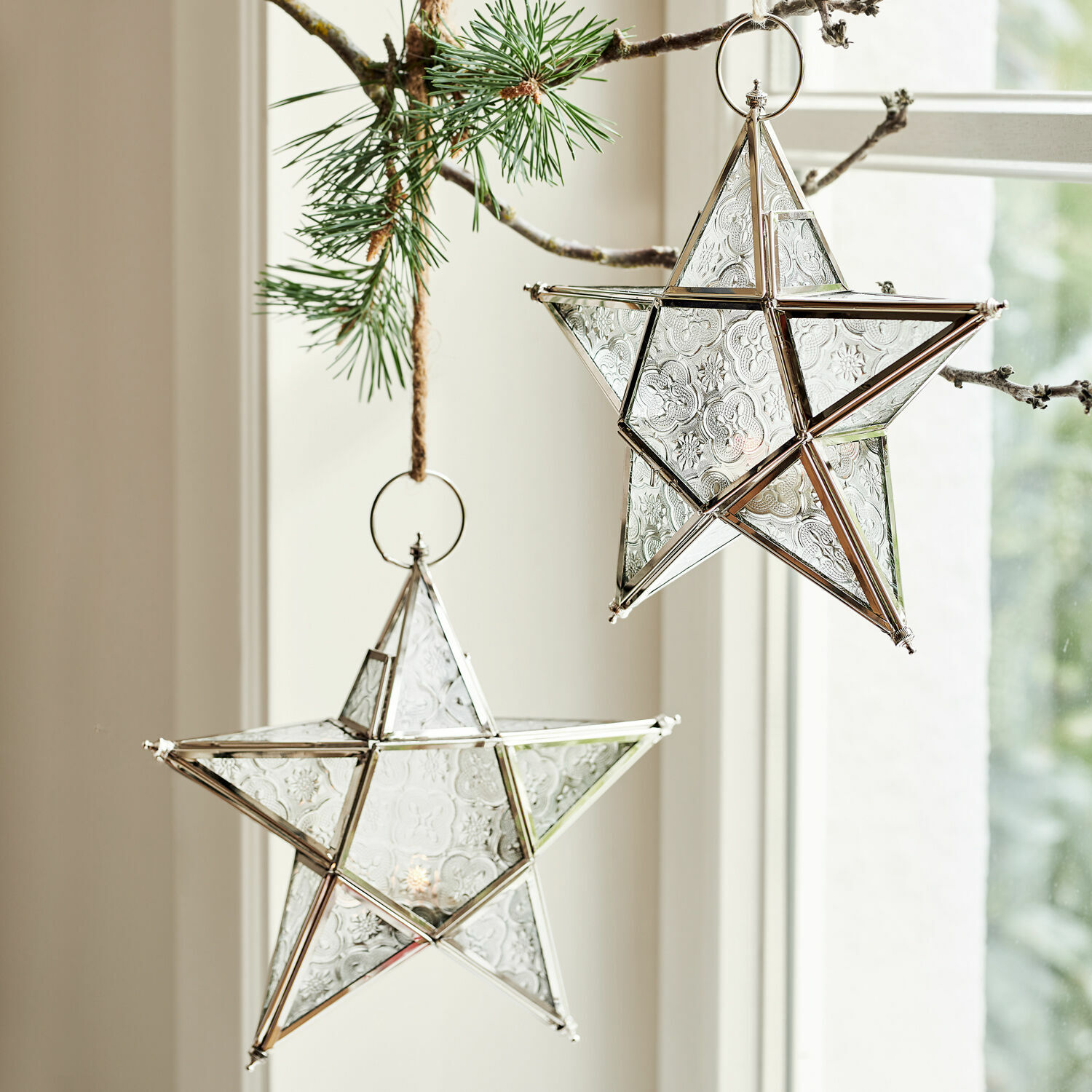 Windlicht set van 2 Kian Glazen sterren met zilverkleurig metalen frame hangend aan een dennen tak, kerstdecoratie