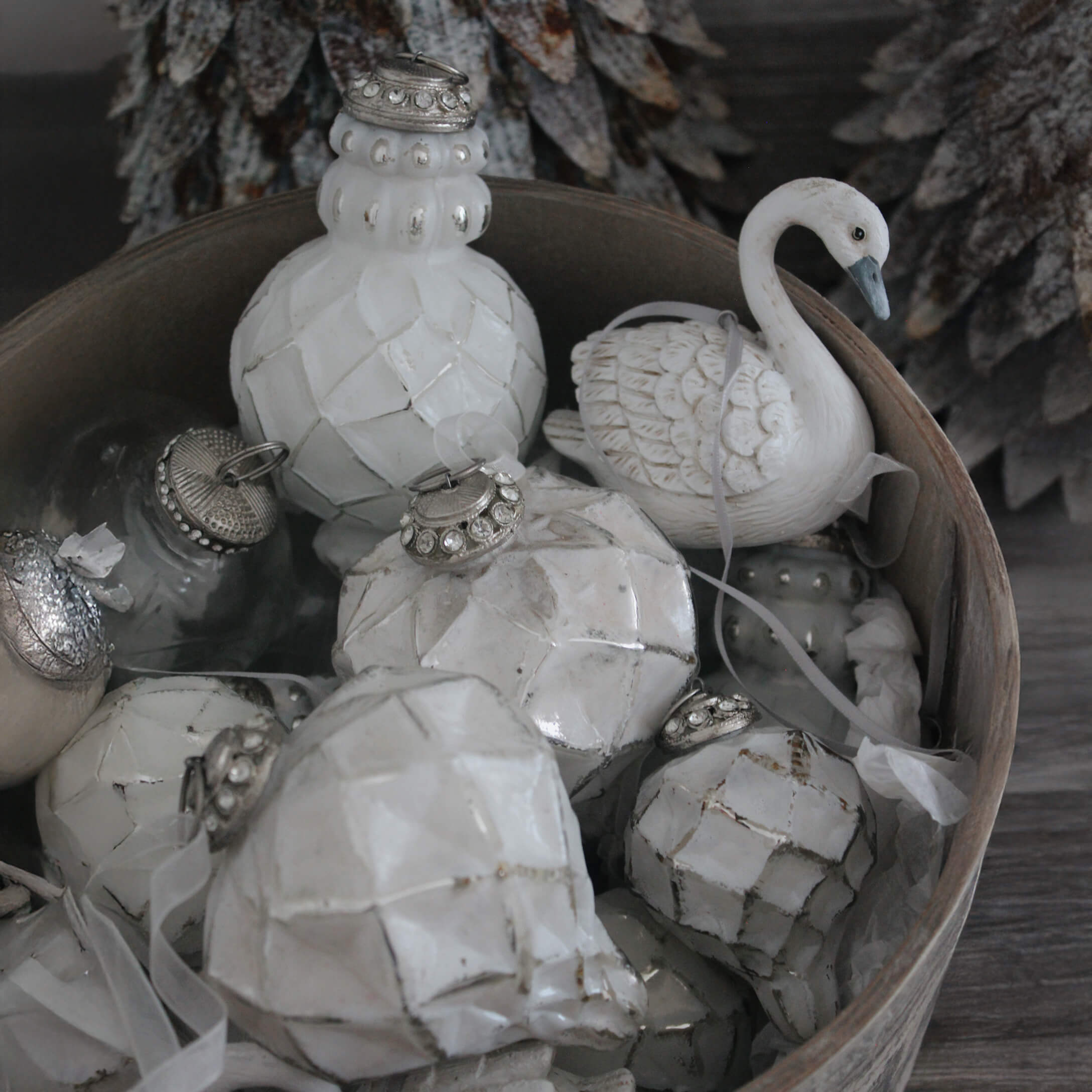 Décorations de Noël blanches en céramique et verre dans un bol en bois, ornements hivernaux