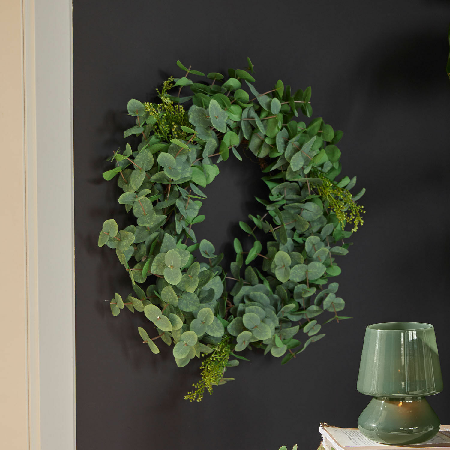 Krans Cranleigh Decoratieve krans van groene eucalyptusbladeren aan donkere muur voor interieurdecoratie