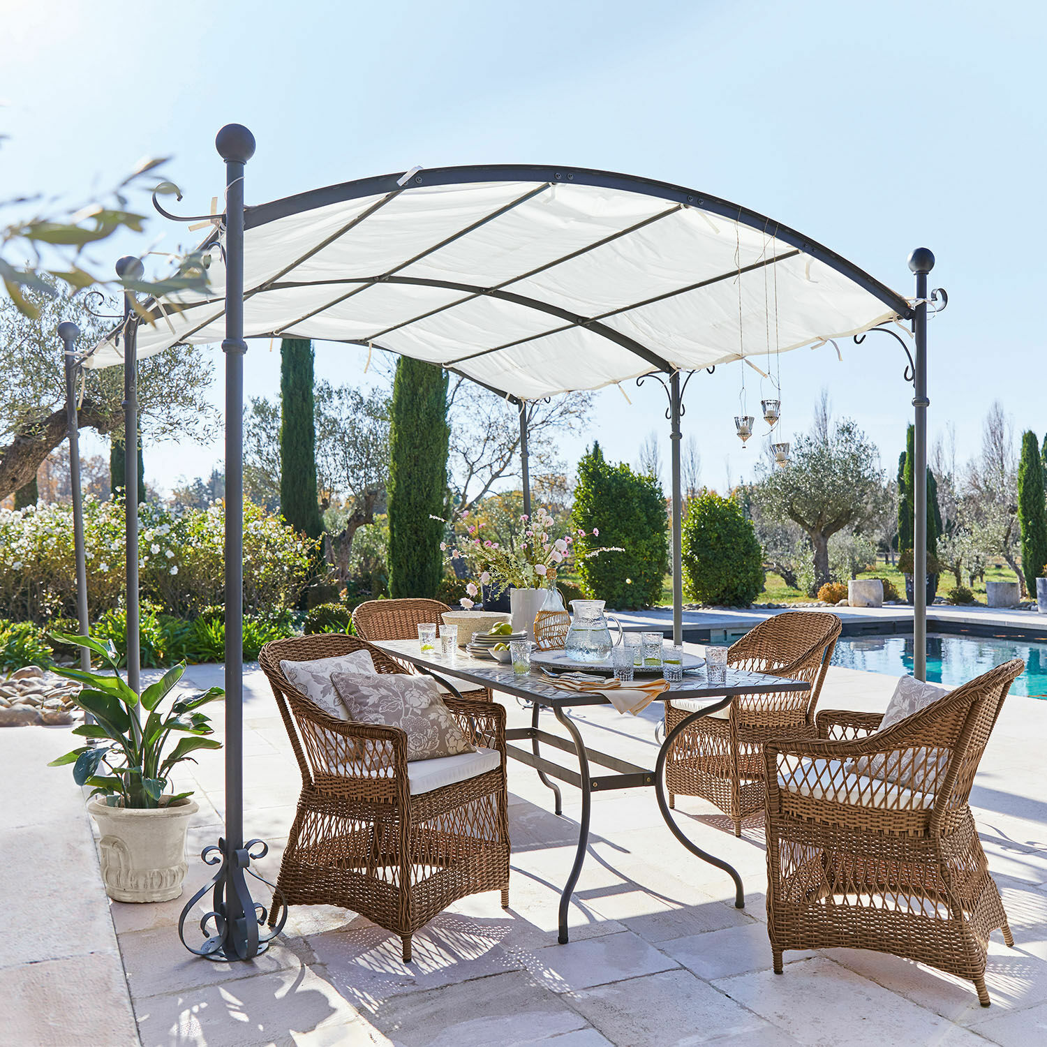 Pergola Yarl Ensemble de mobilier de jardin en rotin marron sous un pavillon blanc en métal près de la piscine