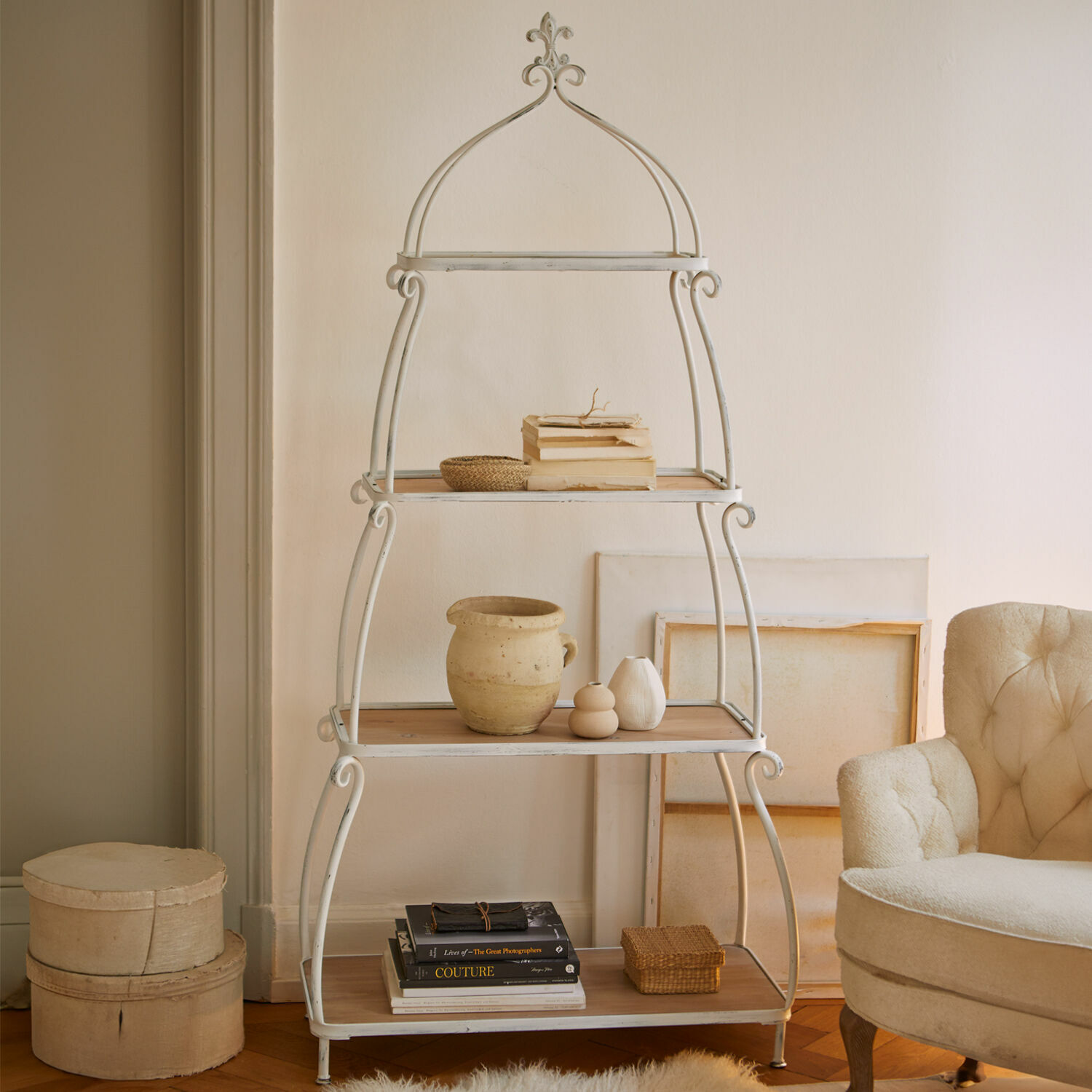 Rek Kellington Witte metalen kast met houten planken in vintage stijl, versierd met boeken en decoraties in woonkamer