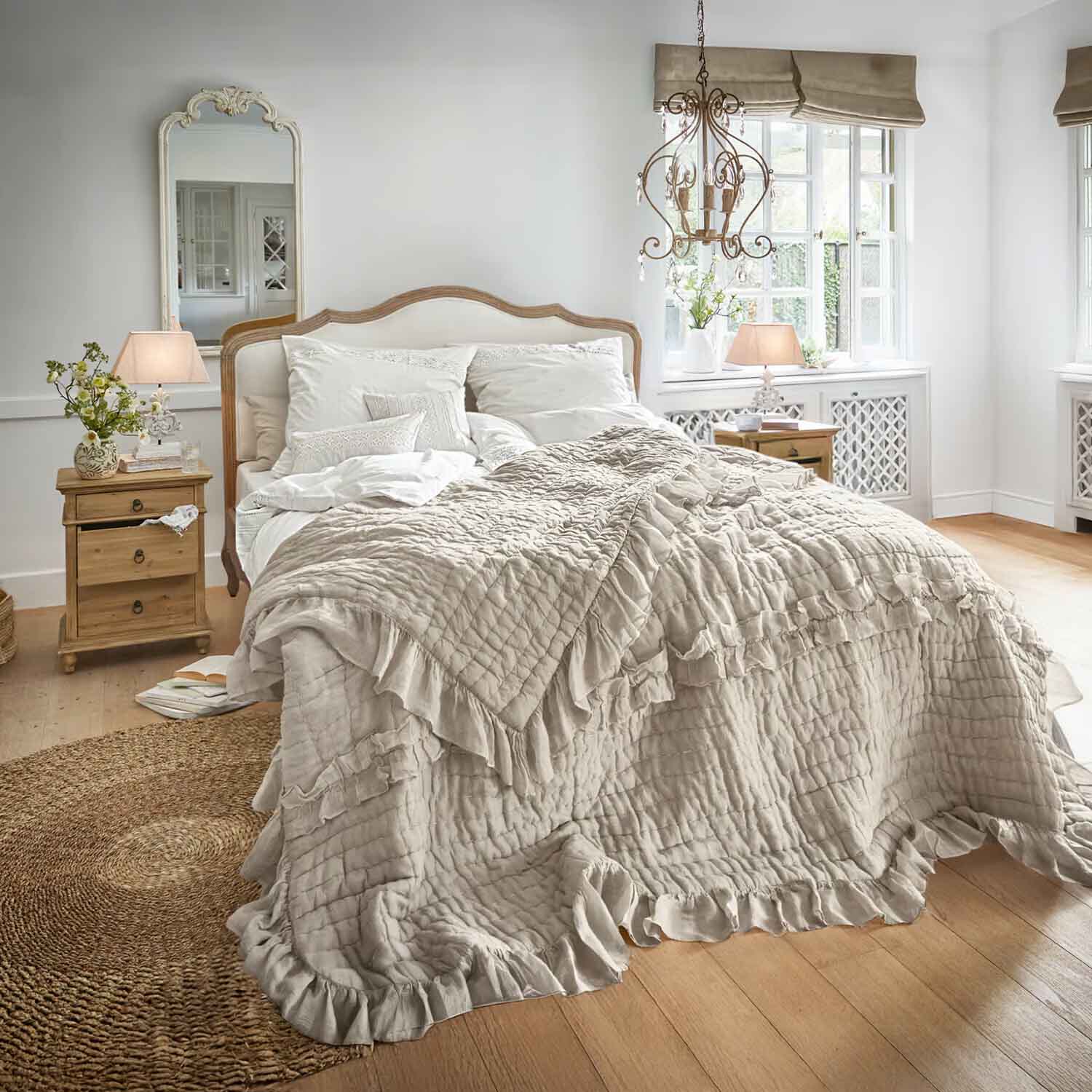 Chambre chaleureuse avec lit en couvre-lit beige à volants et tables de chevet en bois clair