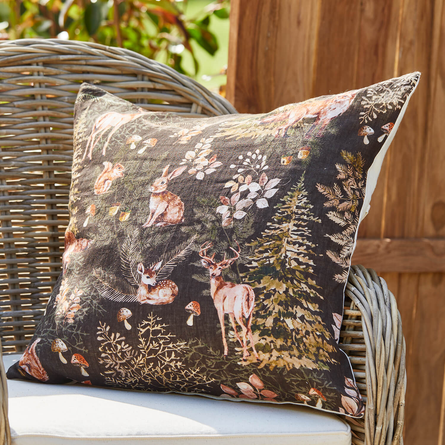 Decoratief katoenen kussen met bosdierenmotief op donkere achtergrond, woonaccessoire