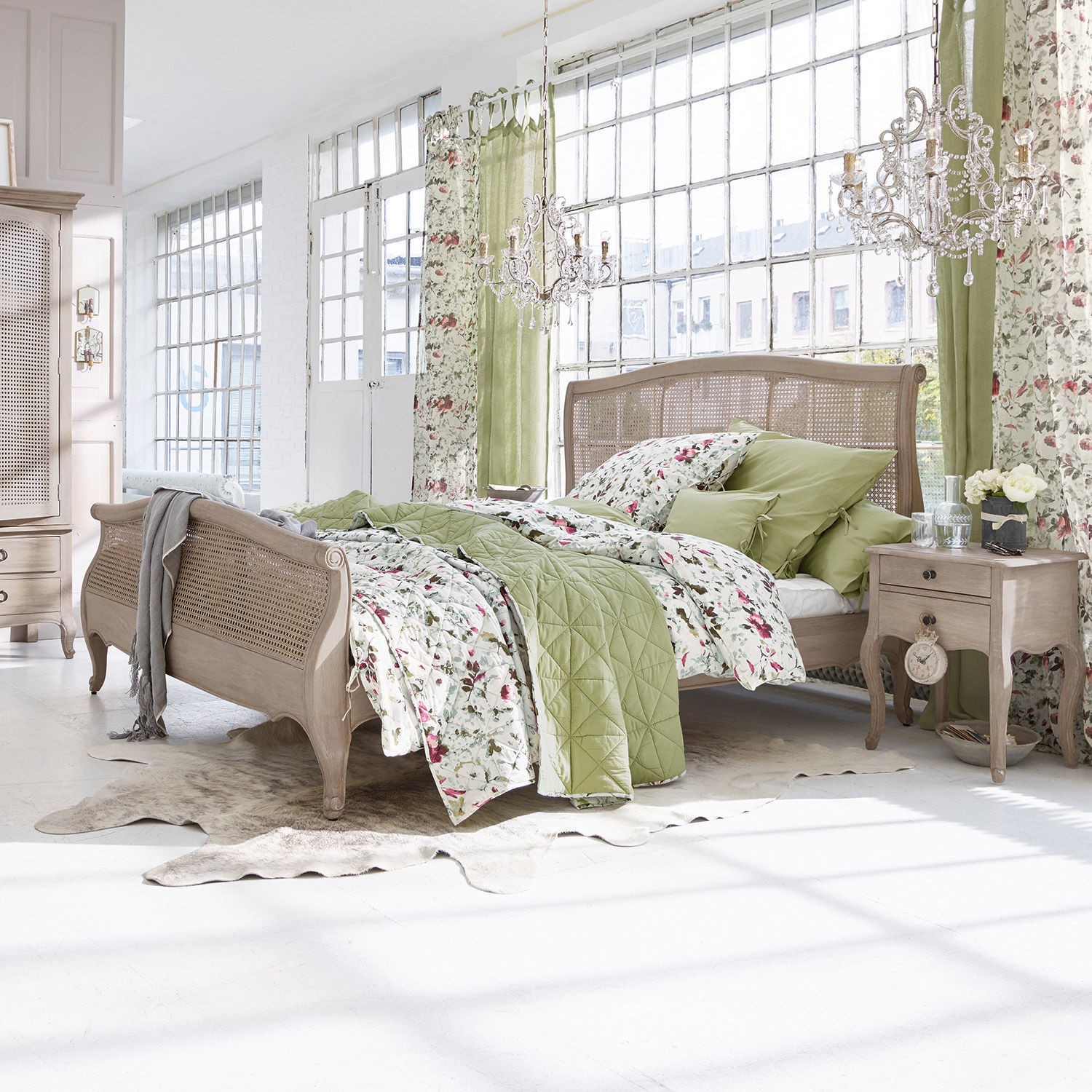 Chambre avec lit en bois et literie verte à motifs floraux dans un style naturel lumineux