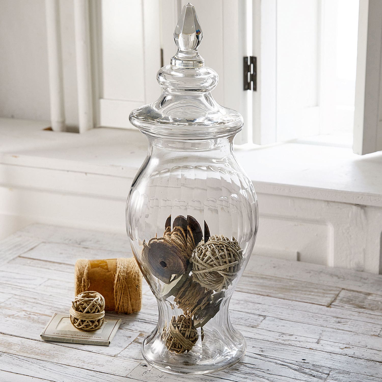 Transparante glazen vaas met deksel en rustieke decoratie, stijlvolle woonaccessoire