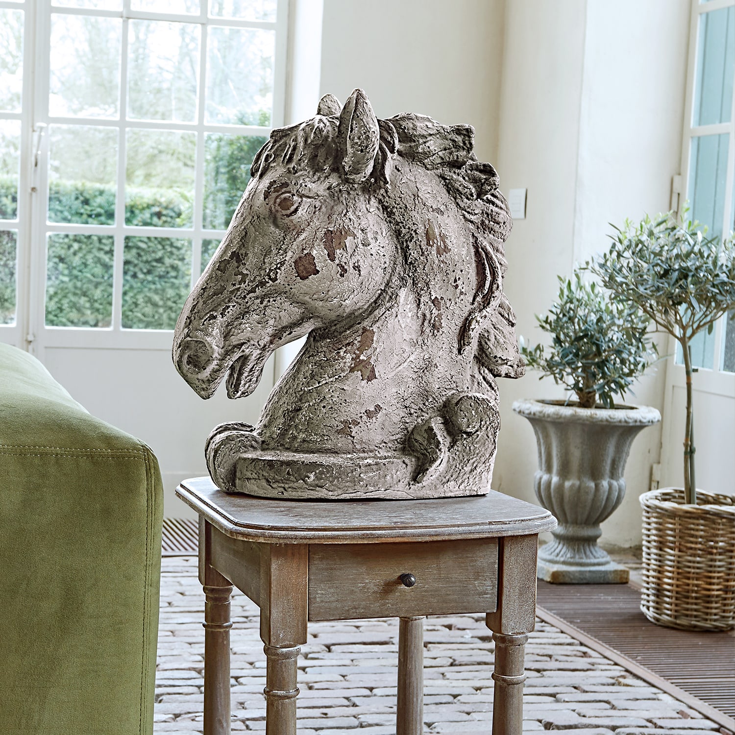 Beeld van paardenhoofd van grijs verouderd beton op houten tafel in lichte kamer