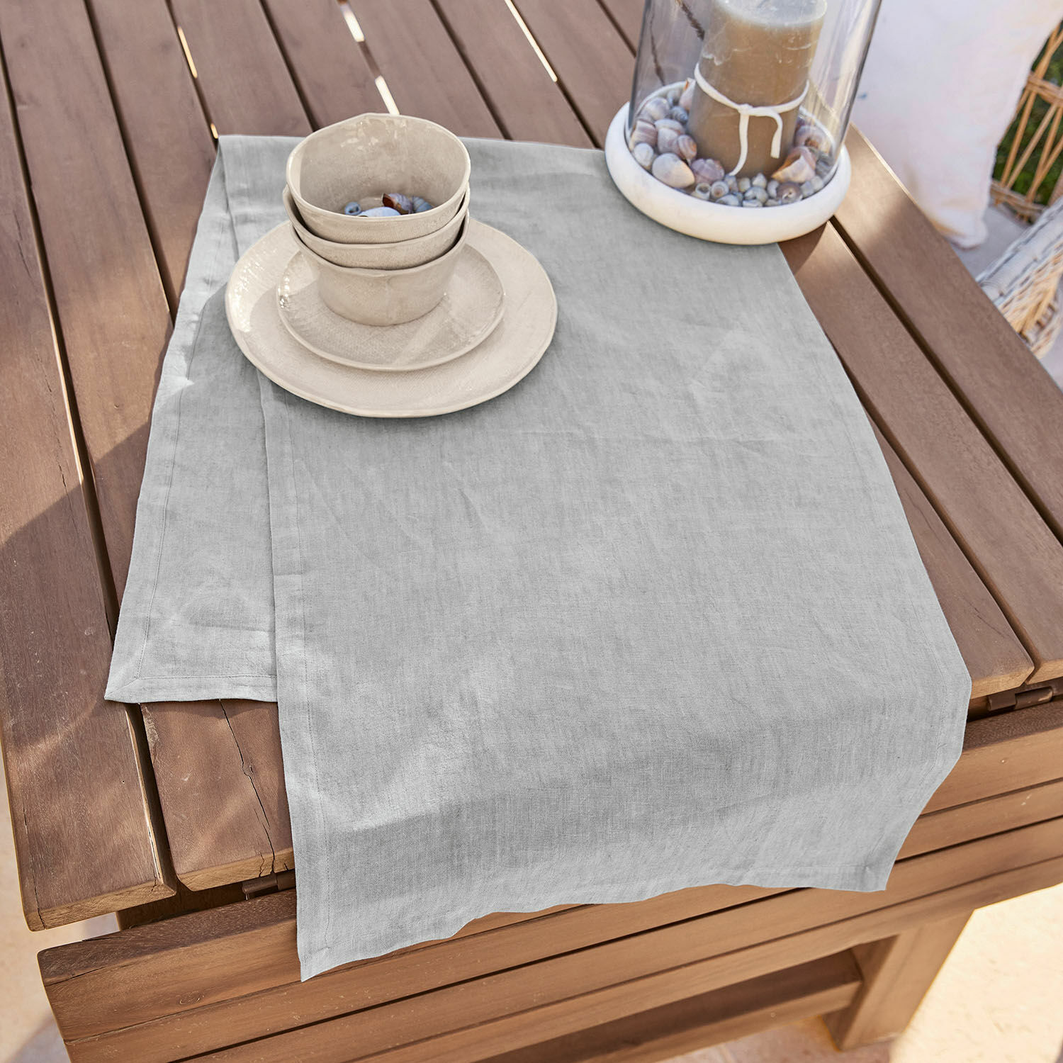Tafelloper Bursinel Lichtgrijze linnen tafelloper op houten tafel met keramisch servies en decoratieve kaars