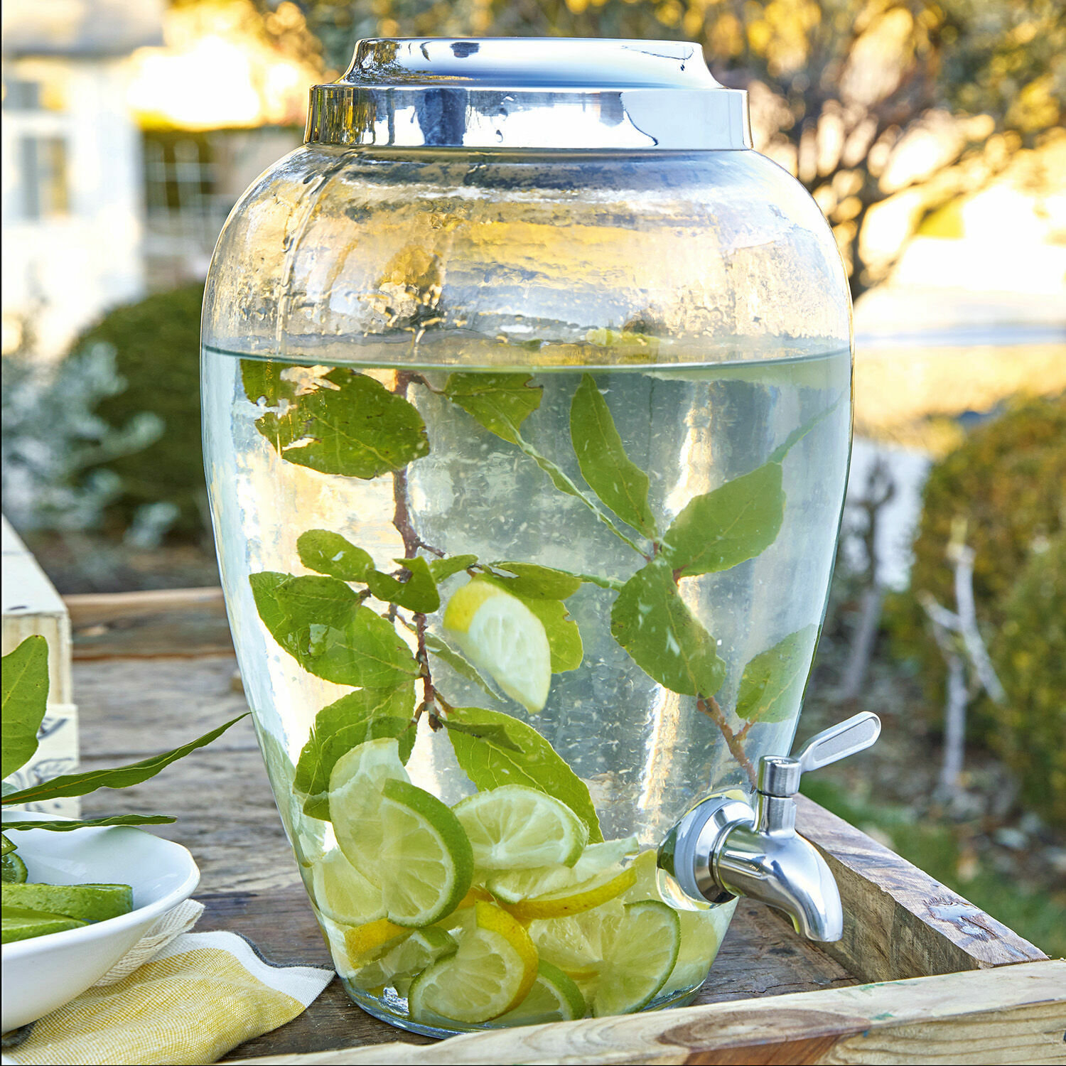 Distributeur de boisson Avrilla Distributeur de boissons en verre avec robinet, rempli d'eau citronnée et feuilles, parfait pour les fêtes d'été