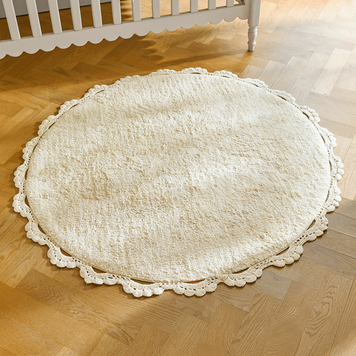 Vloerkleed Arash Ronde crèmekleurige vloerkleed van zacht materiaal met decoratieve kanten rand op houten vloer