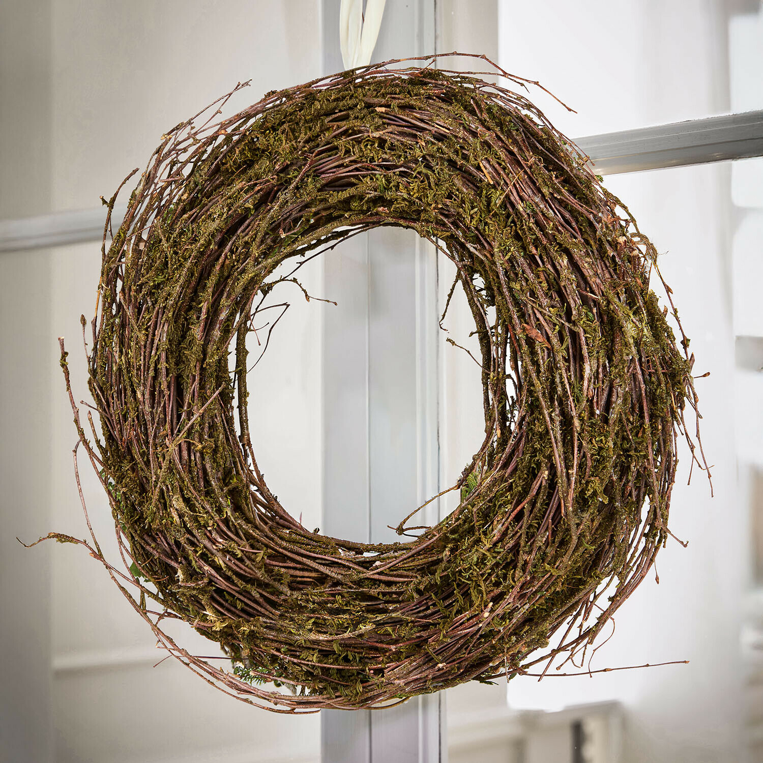 Natuurlijke krans van takken en mos in bruin-groene tinten voor deur- en interieurdecoratie