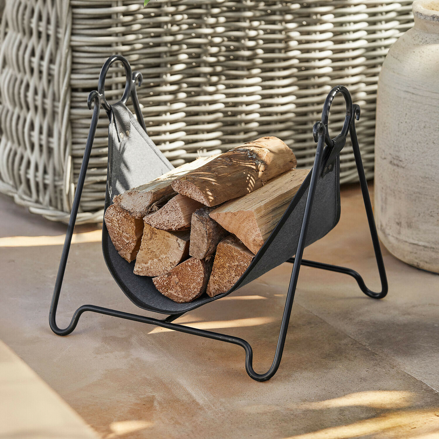 Porte-bûches en métal noir et tissu avec bûches, accessoire pratique pour cheminée