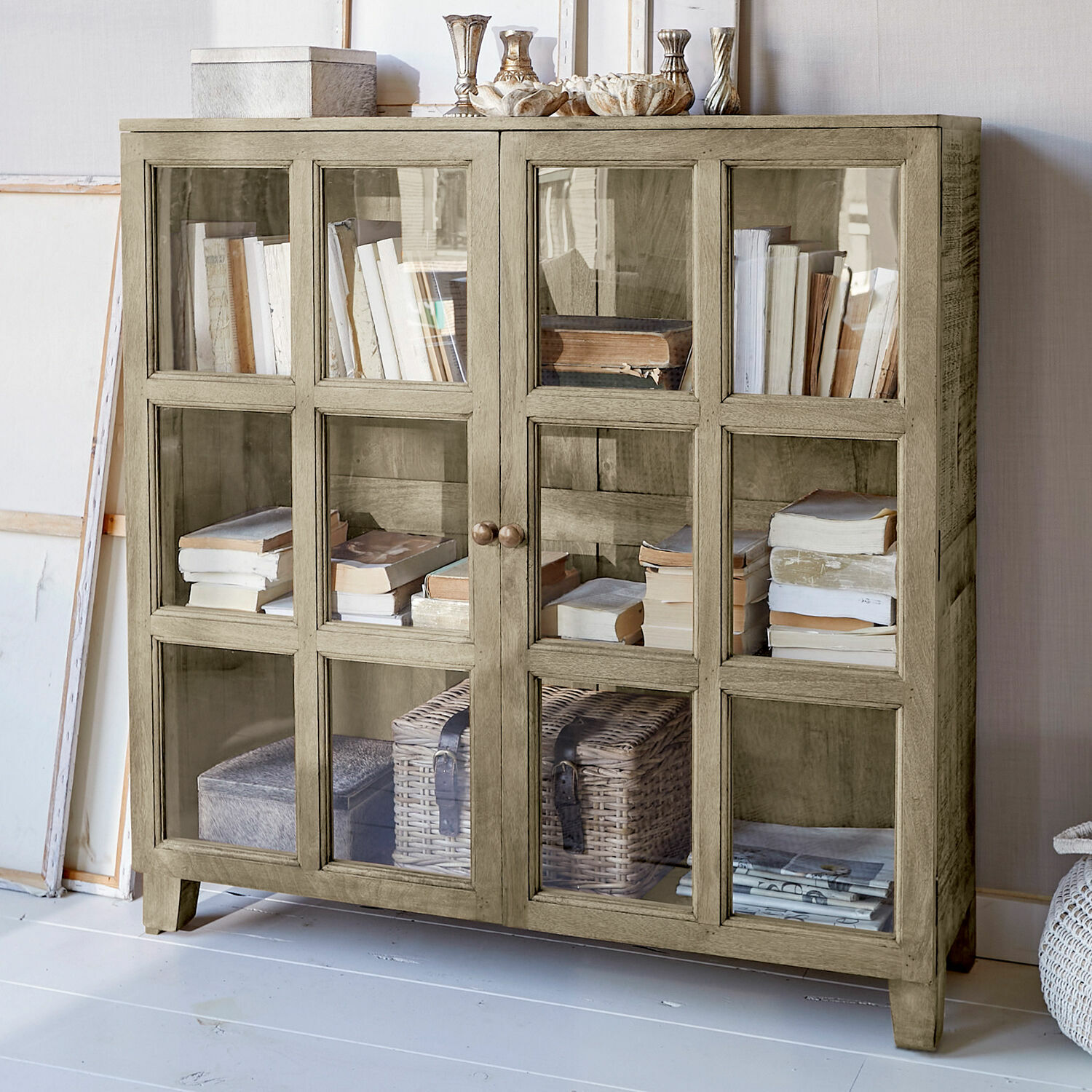 Kast Stoneham Beige houten kast met glazen deuren, gevuld met boeken en decoraties, stijlvolle woonkamermeubel