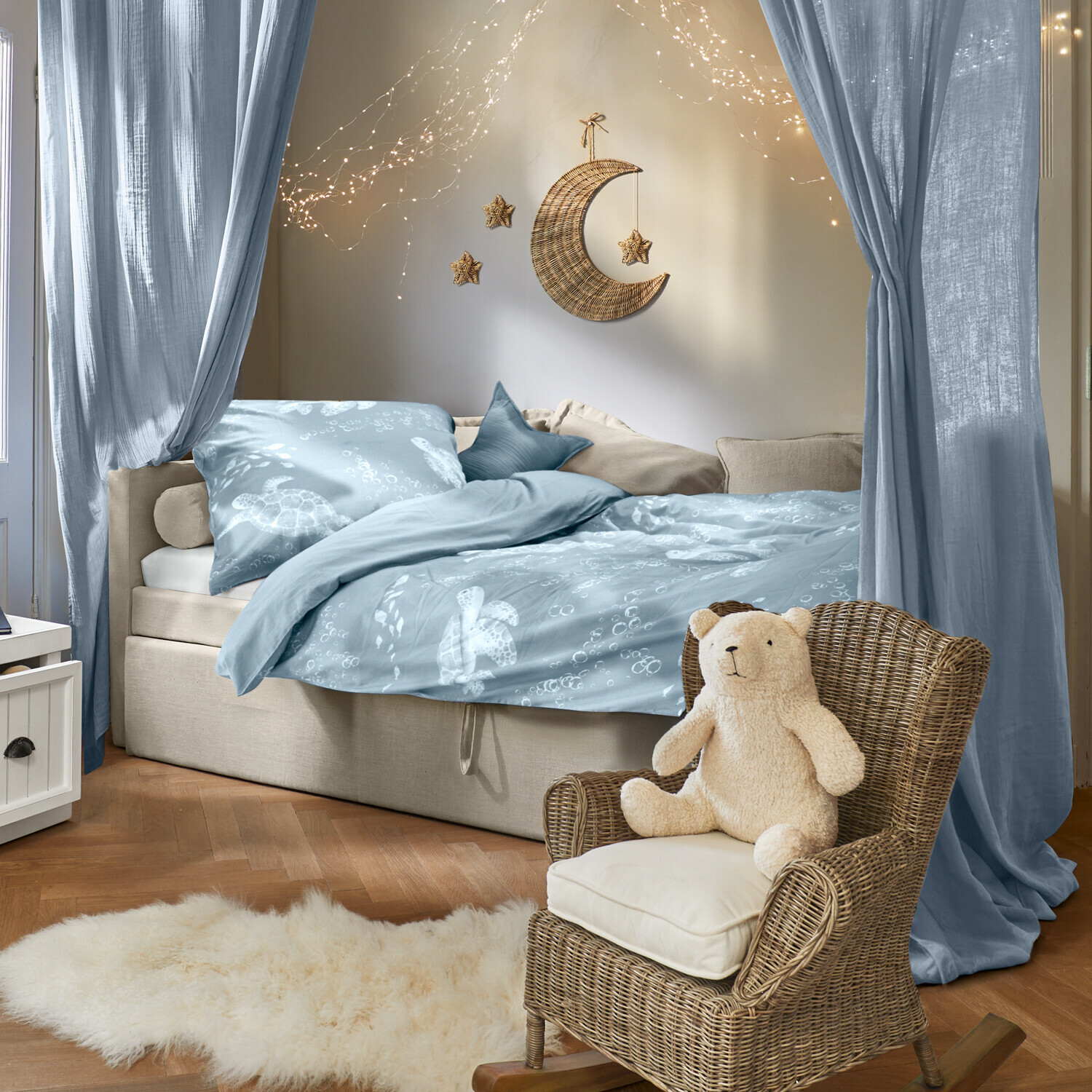 Beddengoed Lomencia Gezellige slaapkamer met blauw beddengoed met schildpaddenmotief en rotan stoel met teddybeer