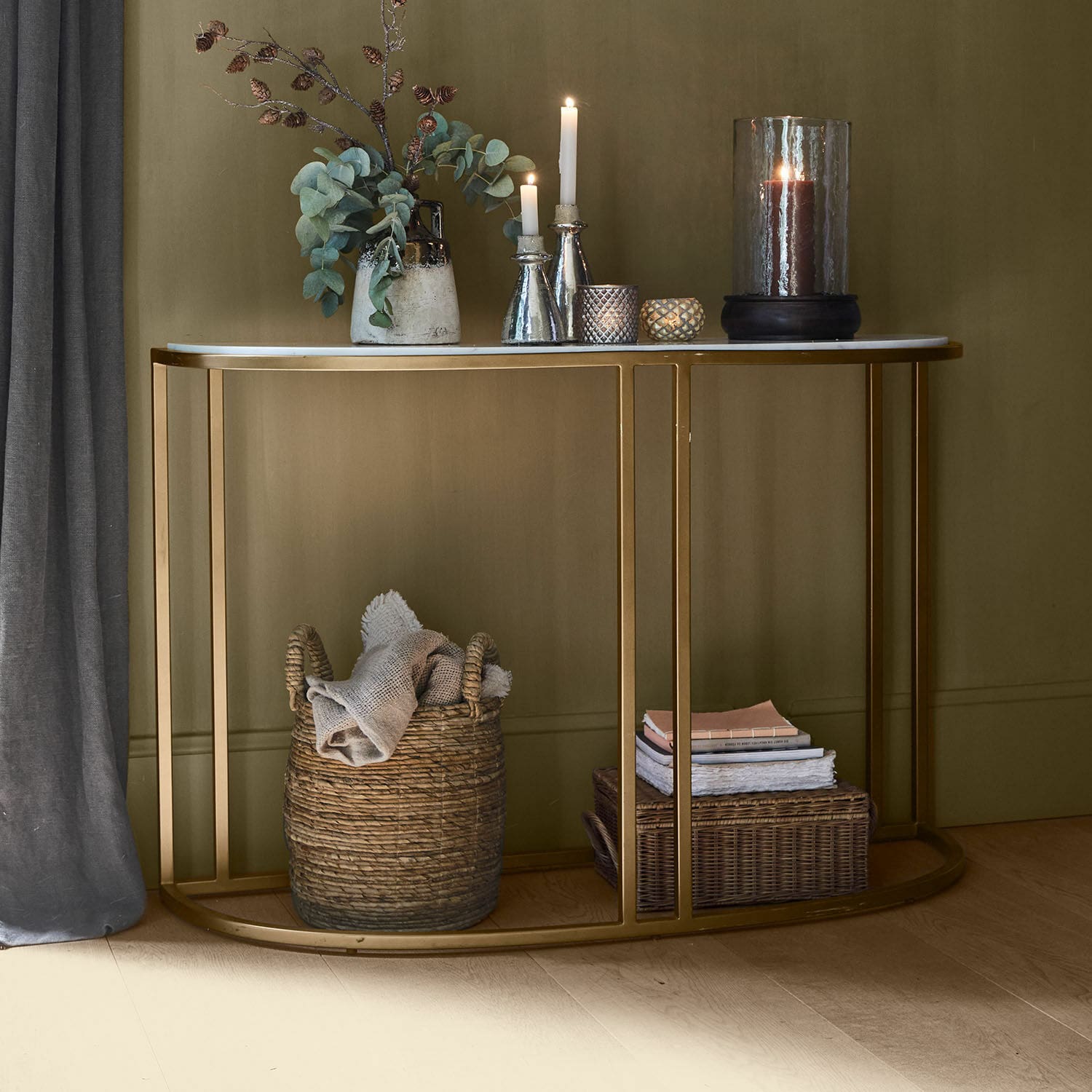 Console Soréline Console avec plateau en marbre blanc et cadre métallique doré, décorée de bougies et vase avec feuillage vert