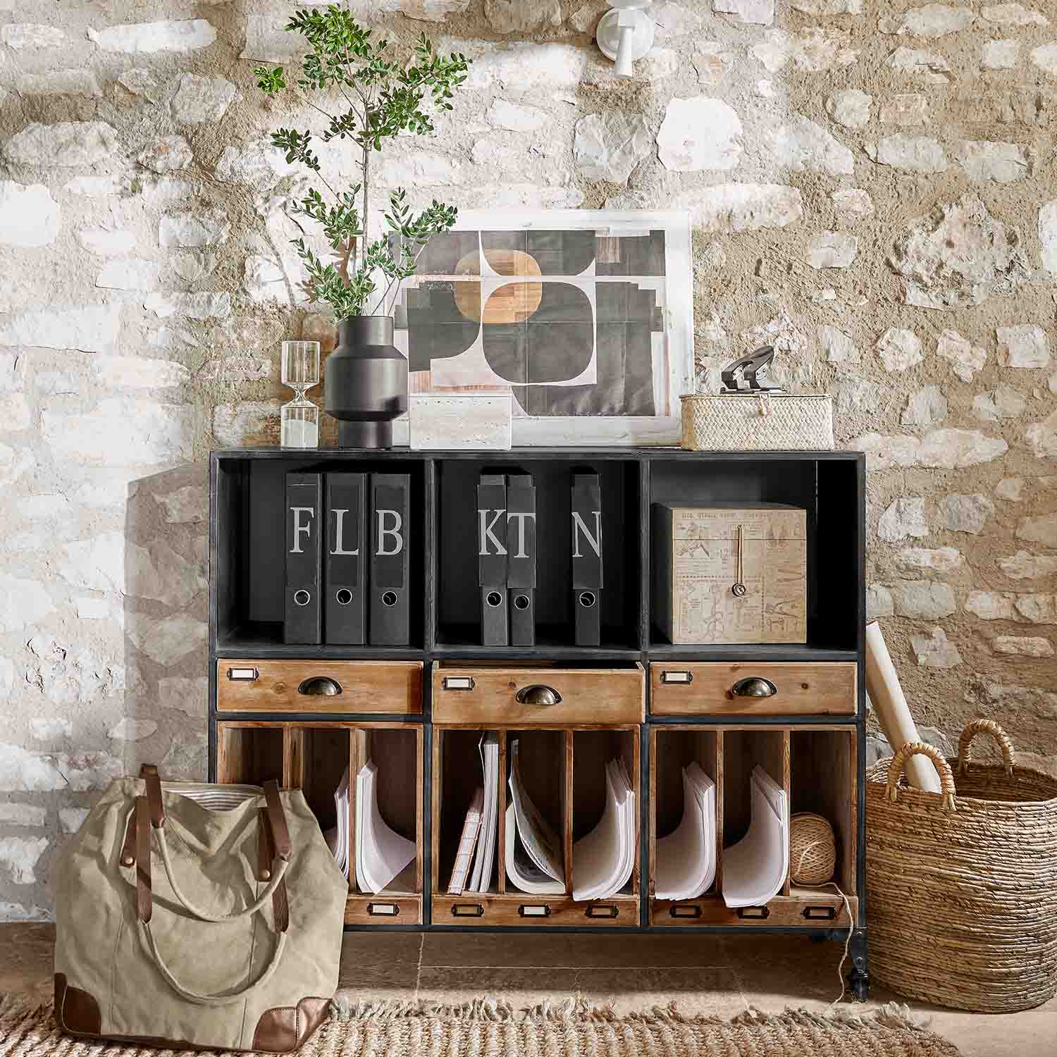 Zwarte metalen en houten kast met lades en ordners tegen een stenen muur in loftstijl