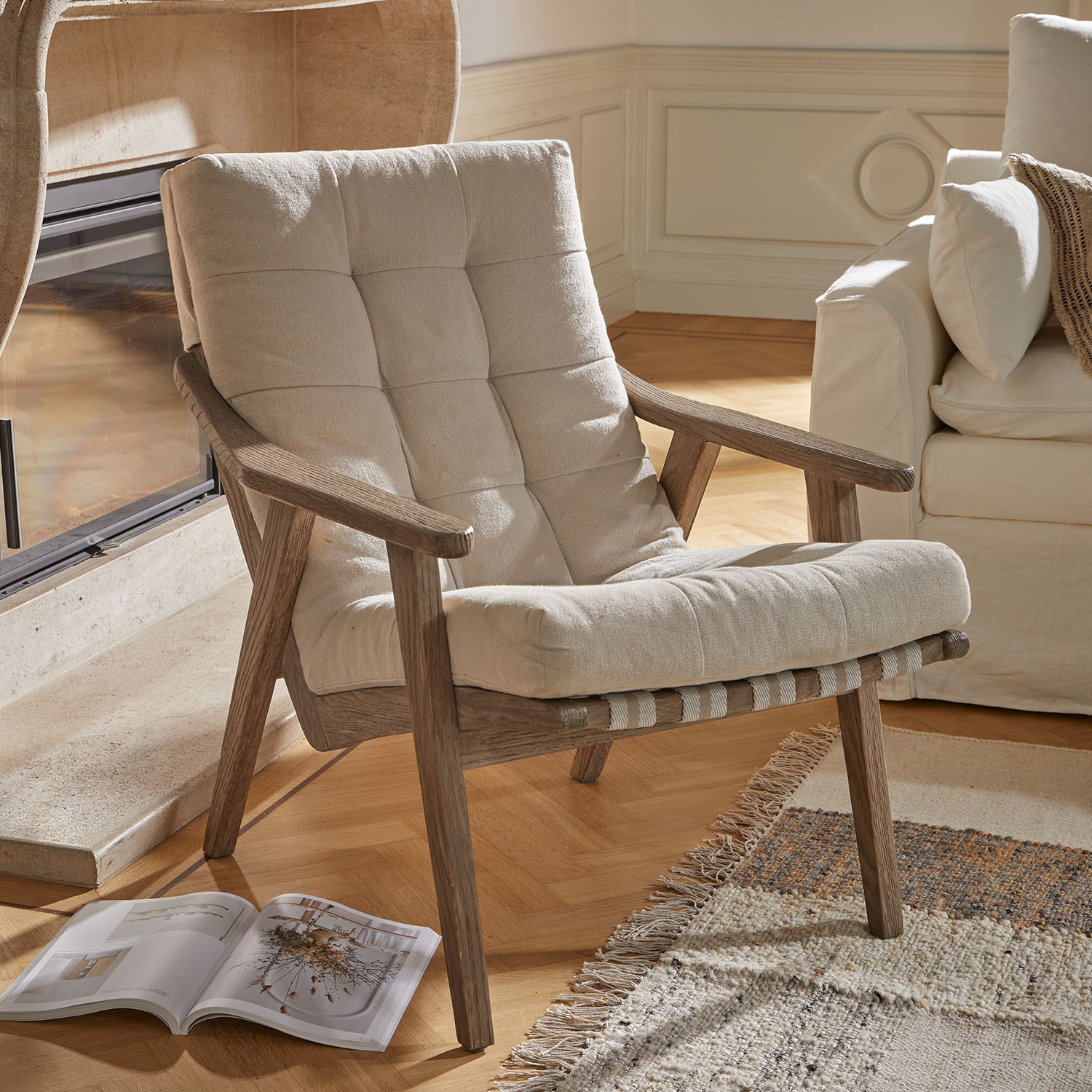 Fauteuil en tissu beige clair avec structure en bois naturel, parfait pour un salon cosy