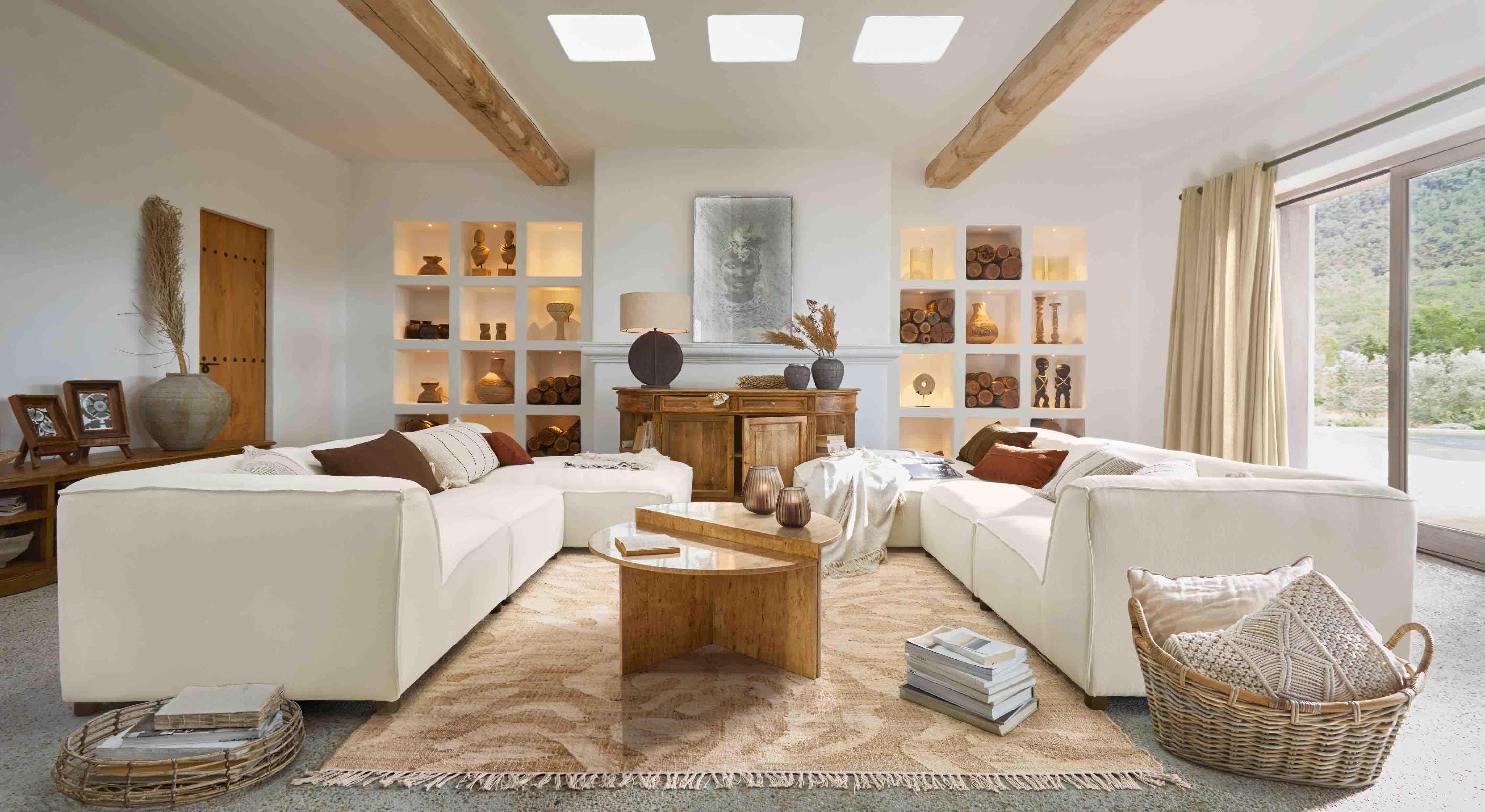 Ruime woonkamer met witte modulaire bank, houten salontafel en decoraties in natuurlijke tinten