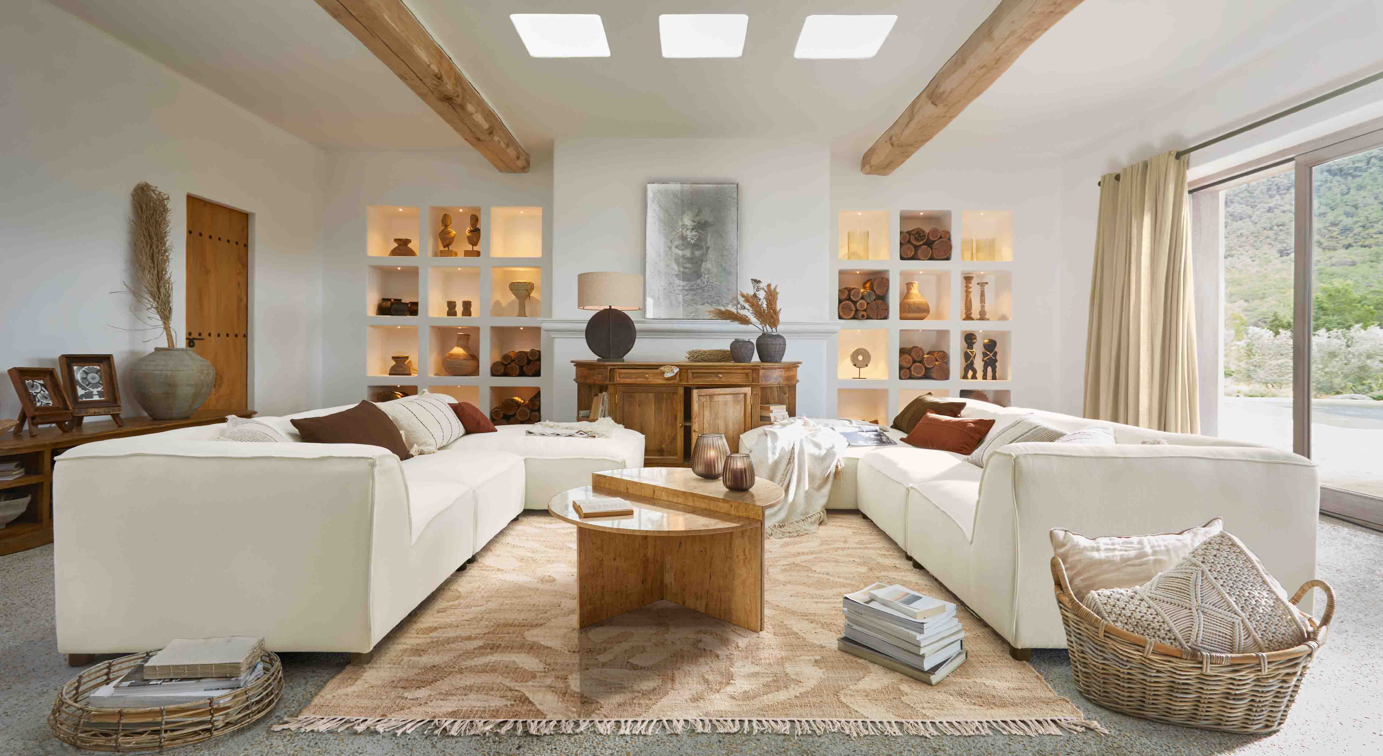 Ruime woonkamer met witte modulaire bank, houten salontafel en decoraties in natuurlijke tinten