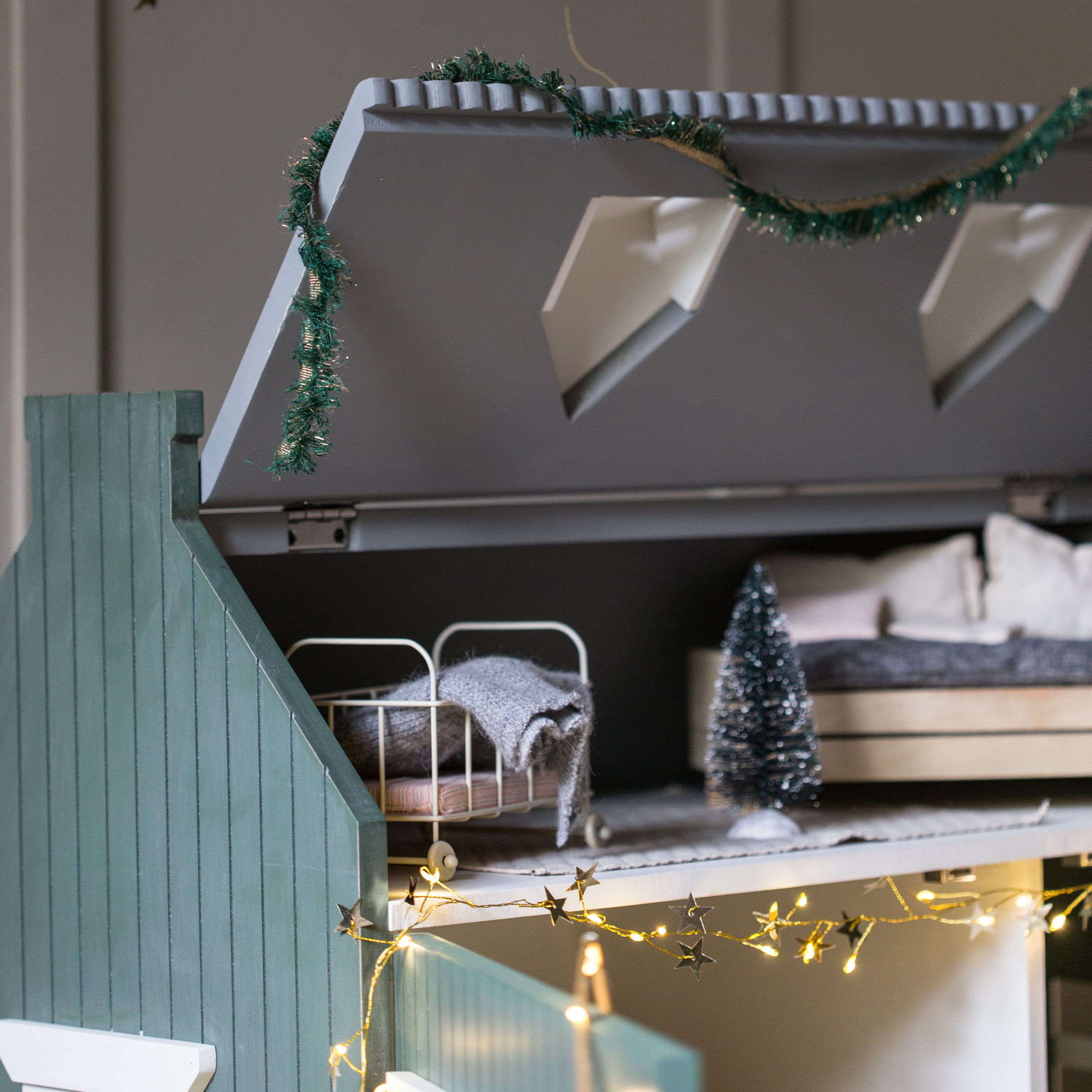 Maison de poupée en bois avec toit vert, lit miniature et guirlande lumineuse décorative