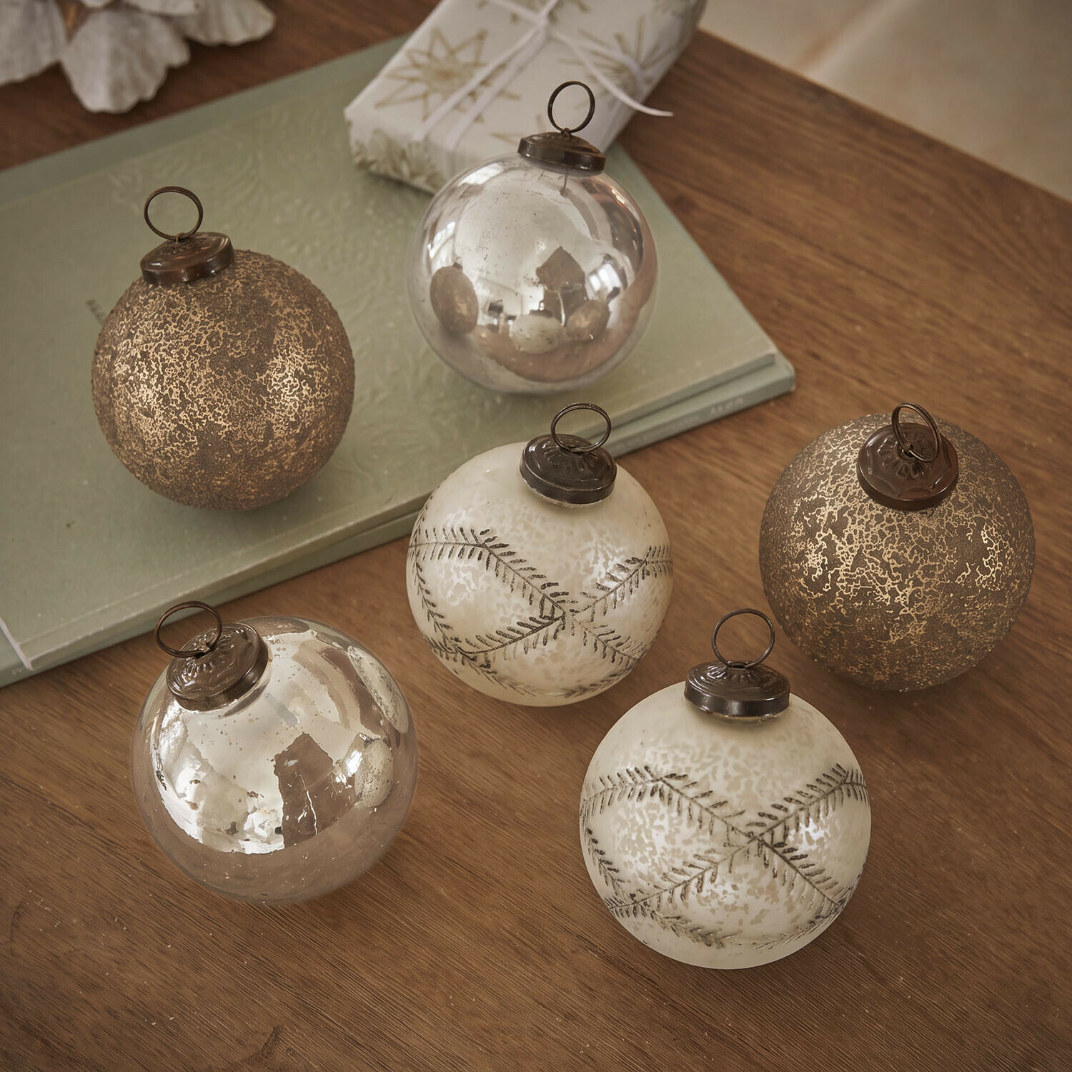Kerstbal set van 6 Fioravino Set van zes gouden glazen kerstballen met verschillende texturen op een houten tafel