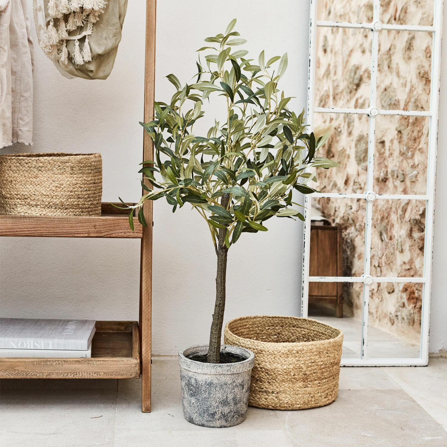 Plante décorative en pot Mariuccia Arbre d'olivier artificiel en pot gris à côté d'un panier en osier et d'un miroir à cadre blanc