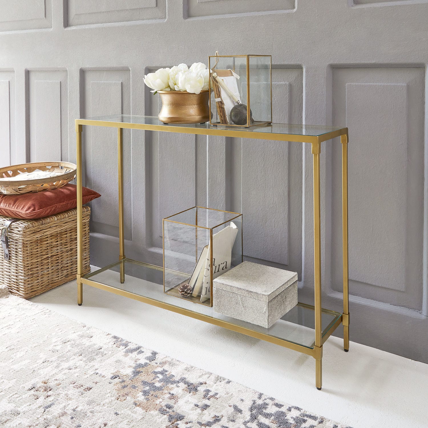 Sidetable Ninove Glazen sidetable met gouden metalen frame, decoraties en rieten mand op de vloer