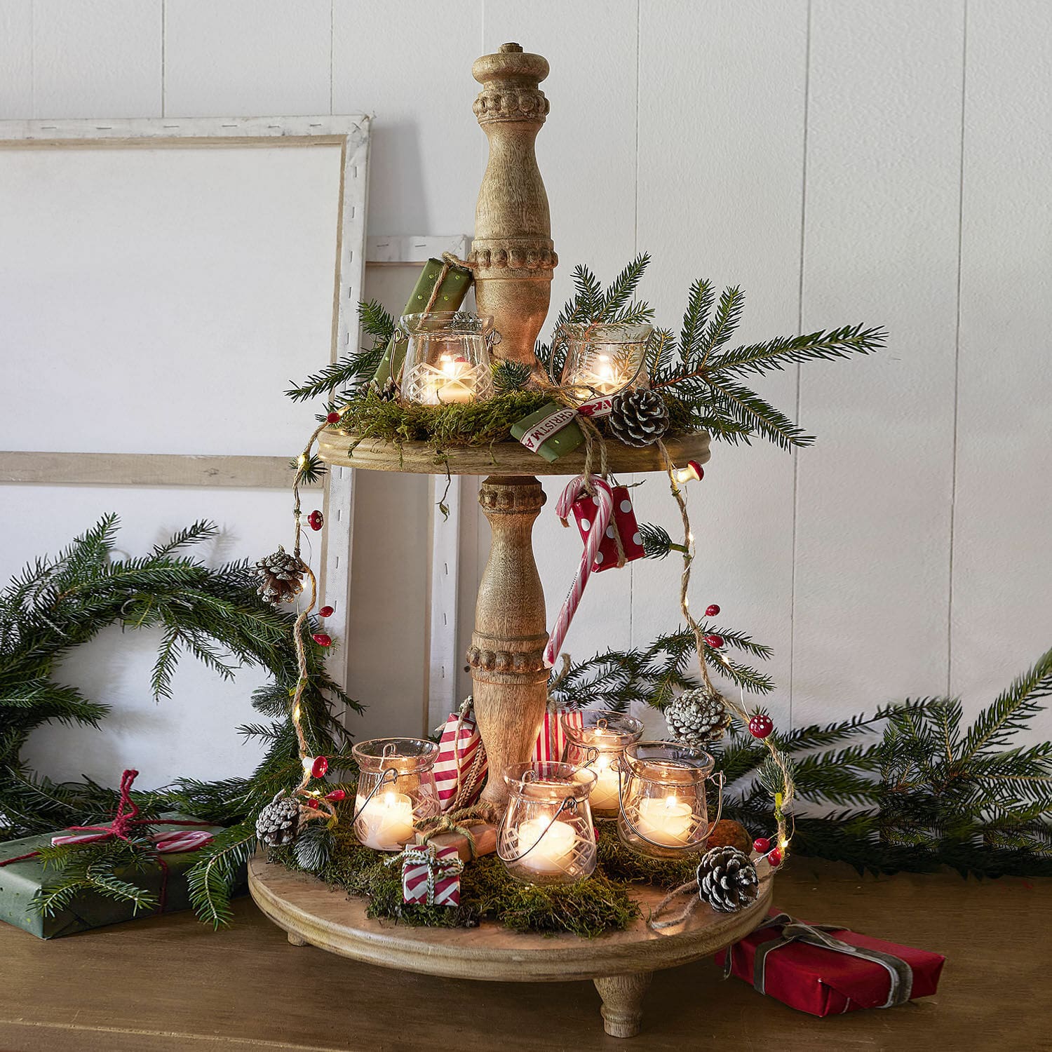 Présentoir à étages Ingham Présentoir en bois à trois niveaux décoré de bougies, branches vertes et cadeaux pour Noël