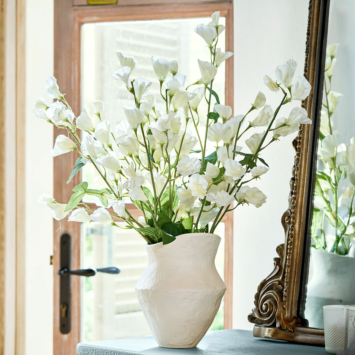 Bloem set van 6 Clavigny Witte keramische vaas met witte decoratieve bloemen op tafel naast een antieke spiegel