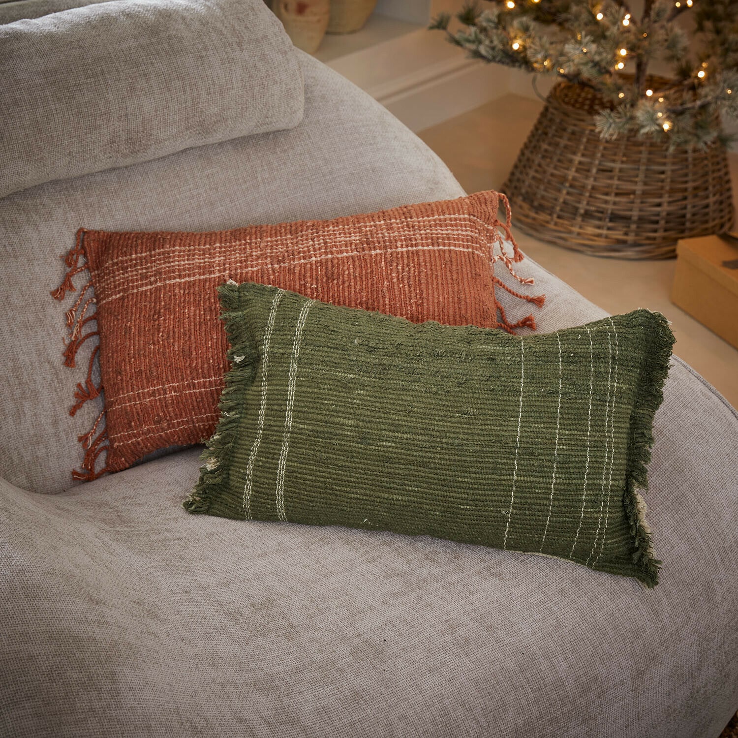 Kussenhoes set van 2 Winlow Twee decoratieve kussens van stof in groen en baksteenrood op een lichtgrijze bank, woontextiel