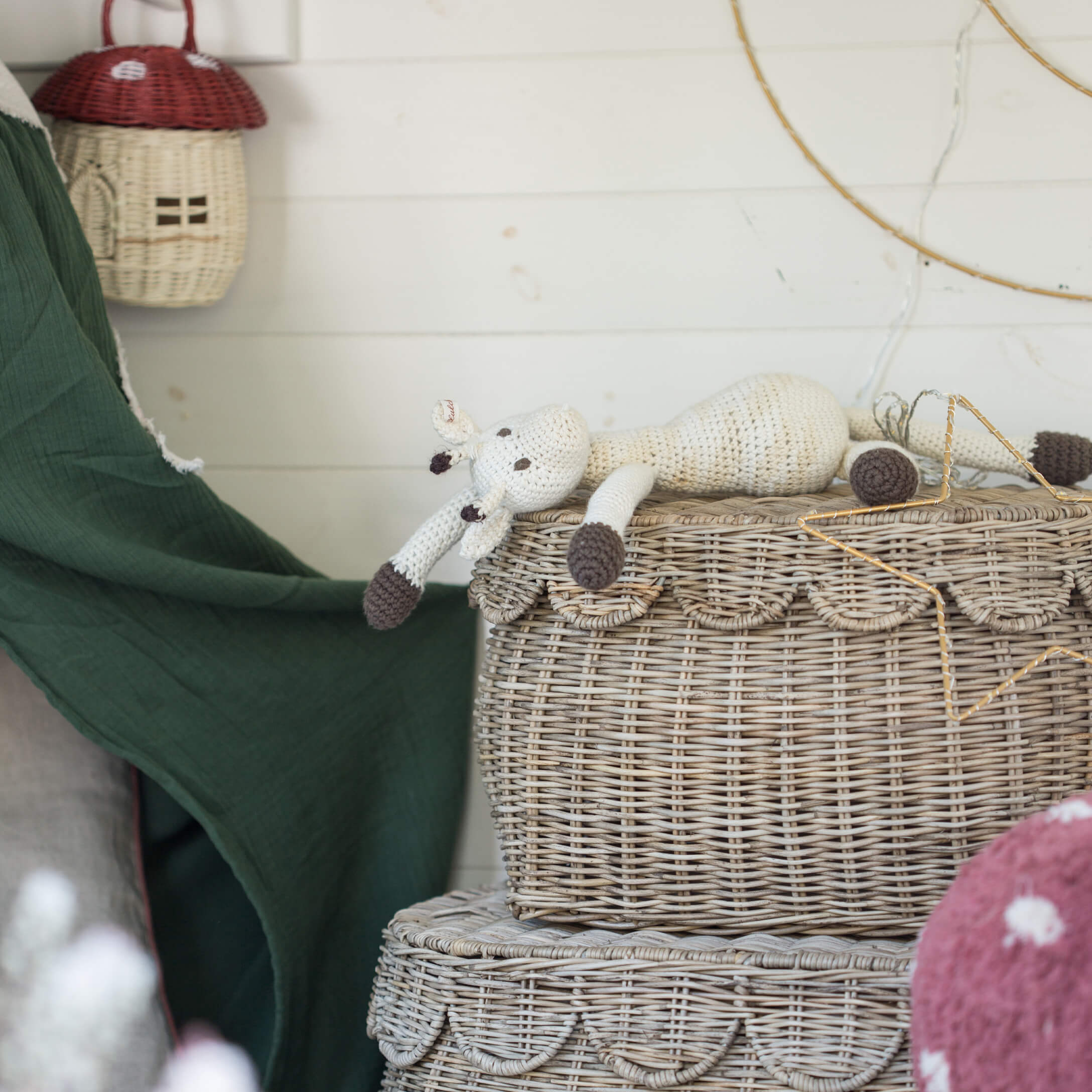 Jouet girafe en crochet blanc et marron posé sur un panier en osier décoratif style bohème