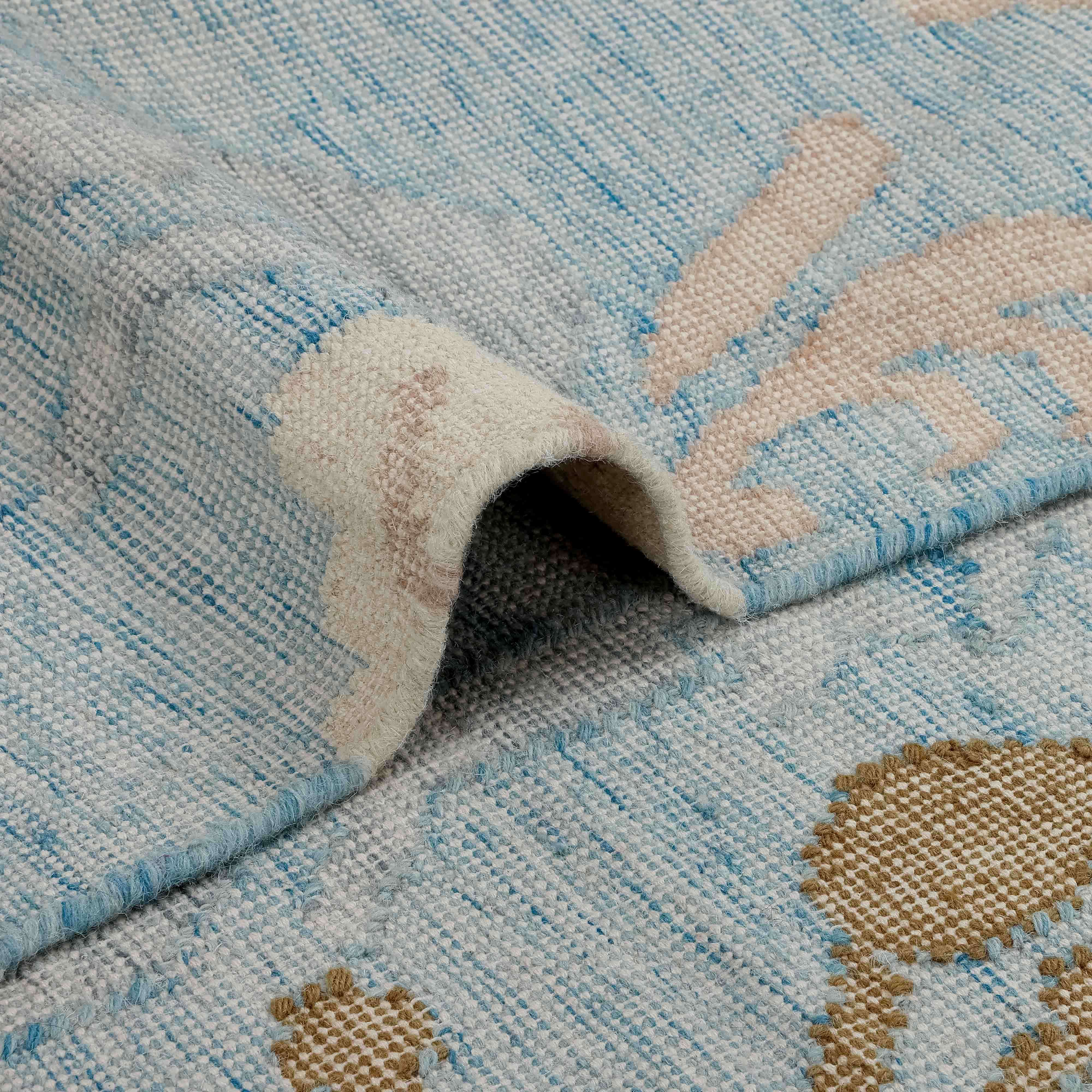 Zachte vloerkleed in blauw-beige tinten met subtiel patroon, stijlvolle woondecoratie