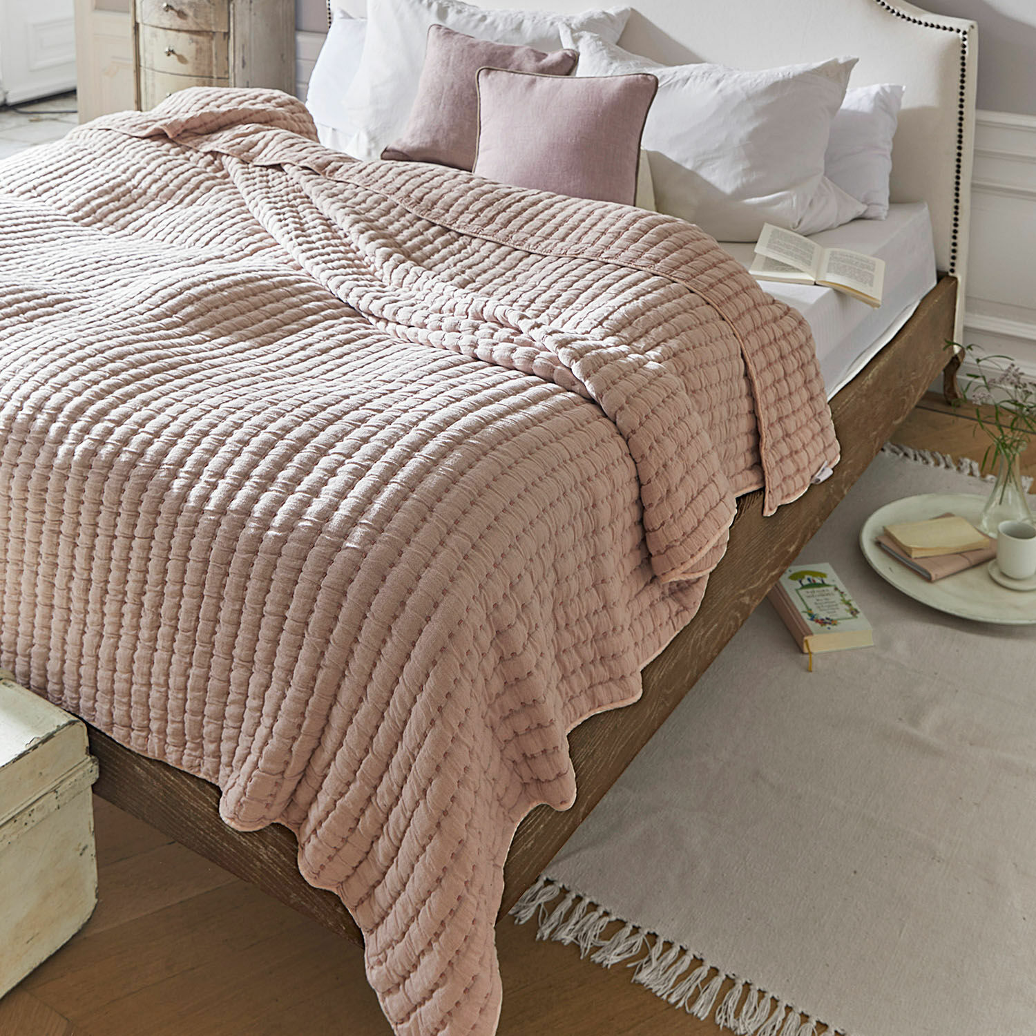Quilt Herepian Roze gewatteerde katoenen deken op houten bed met wit beddengoed in gezellige slaapkamer