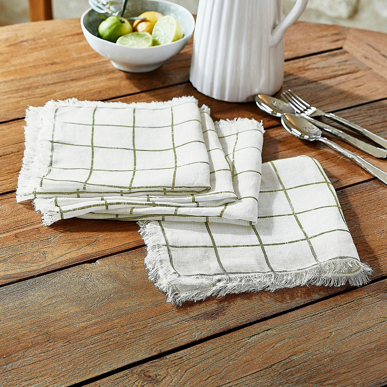 Servet set van 4 Klivento Witte linnen servetten met groen ruitpatroon en franjes op houten tafel voor tafeldecoratie