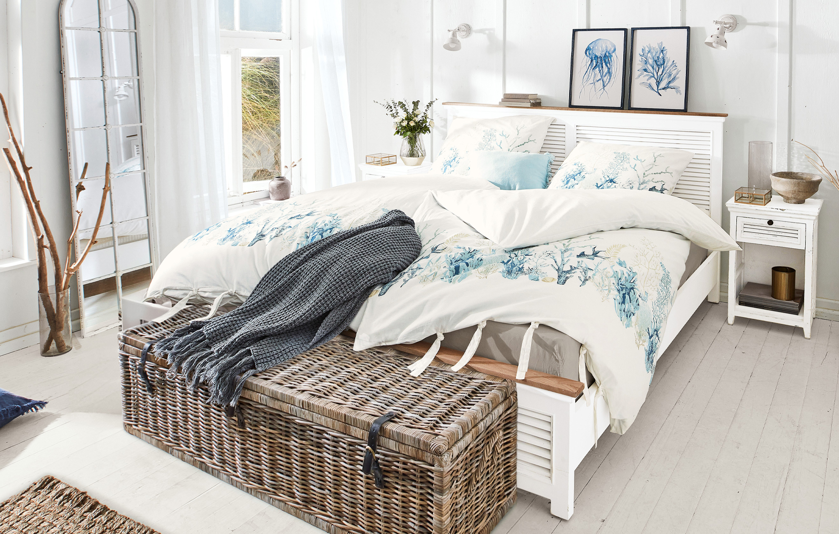 Chambre marine avec lit blanc et linge de lit décoré de motifs marins bleus et coraux