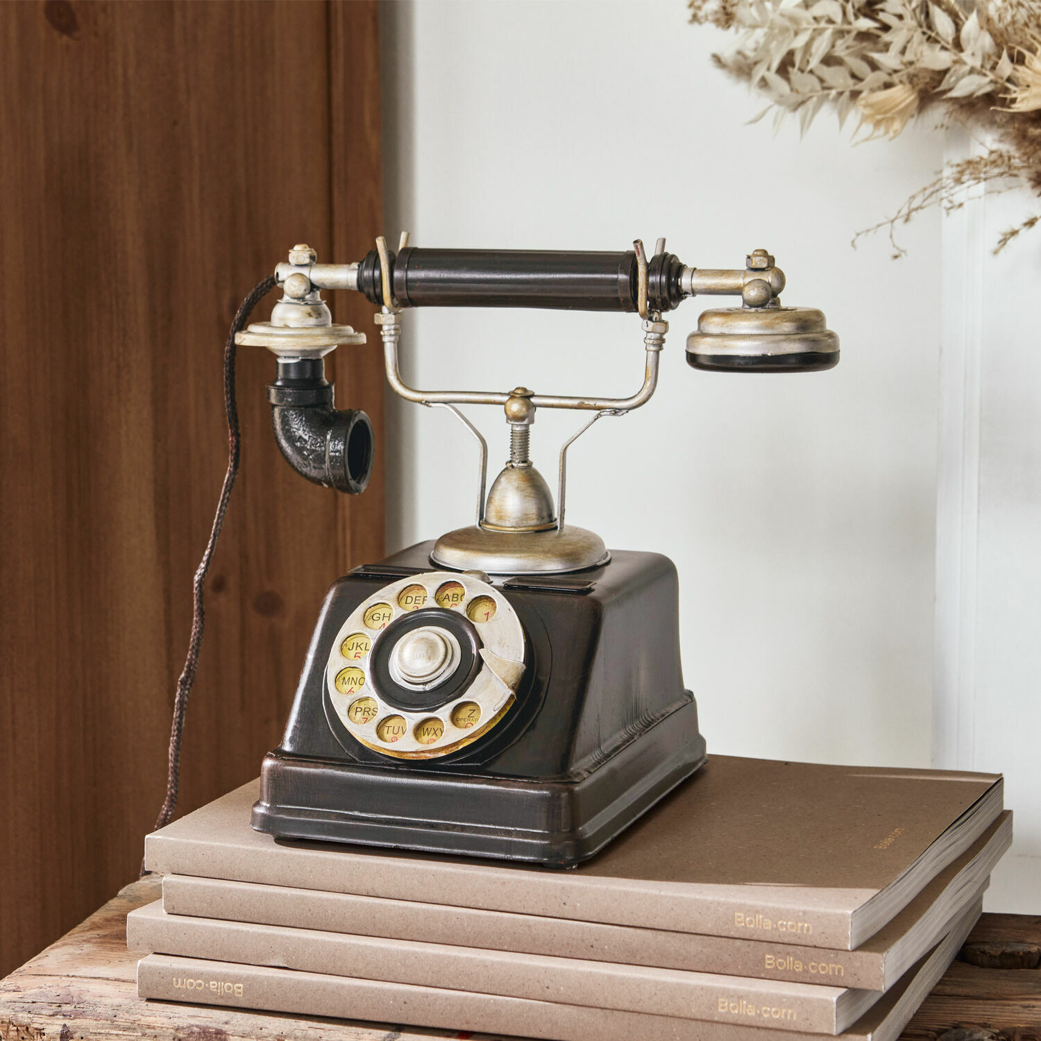Decoratietelefoon Upavon Oude zwarte draaischijftelefoon met metalen onderdelen op stapel bruine boeken