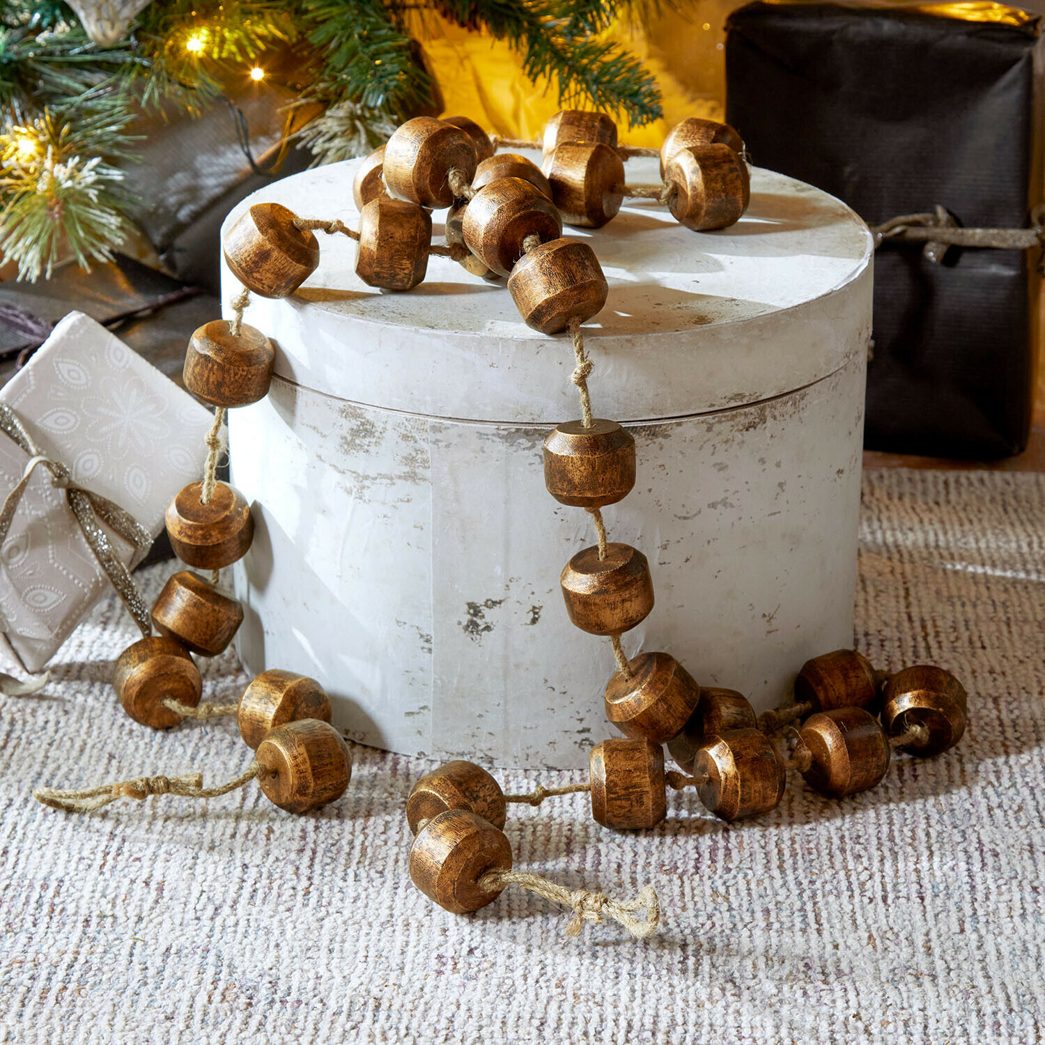 Guirlande Caralinas Decoratieve ketting van bruine houten kralen op lichte ondergrond, feestelijke kerstversiering