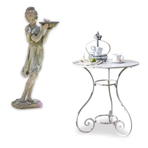 Statue décorative verte d'une femme tenant un plateau à côté d'une table ronde blanche en métal avec tasses