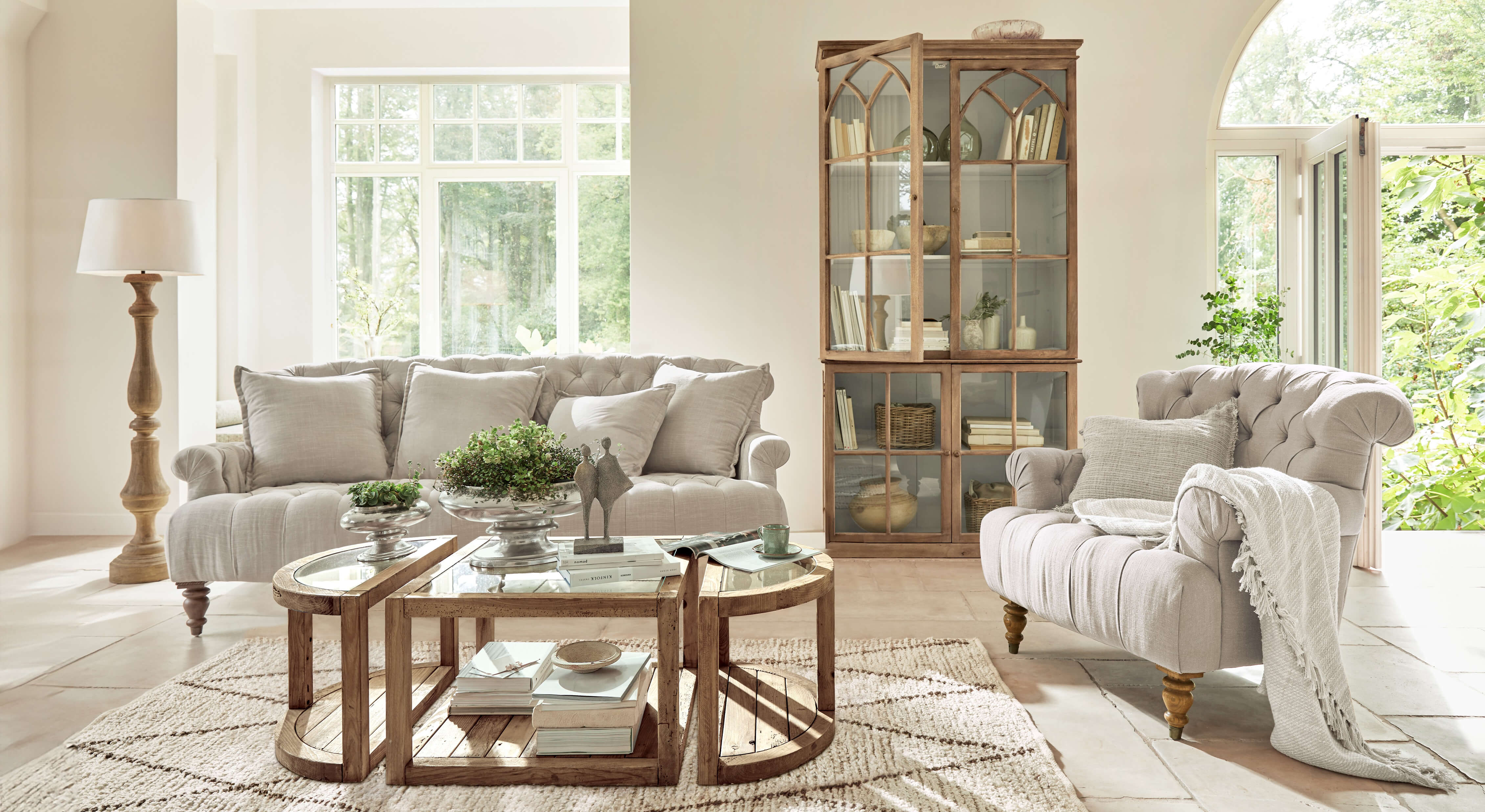 Gezellige woonkamer met beige stoffen bank en fauteuil, houten meubels en rustieke salontafel