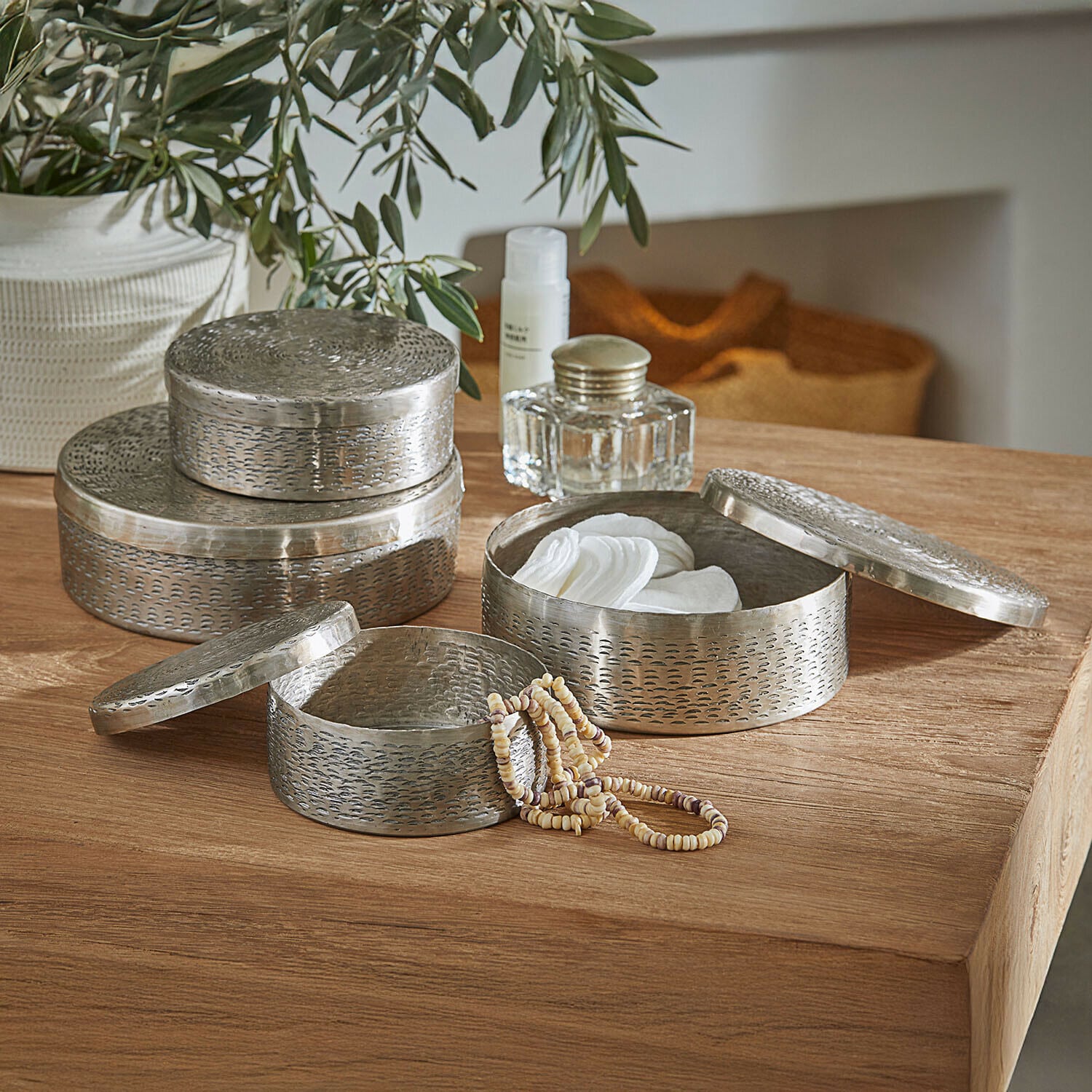 Blik set van 4 Silvaras Set van drie ronde metalen zilverkleurige opbergdozen voor cosmetica en sieraden op houten tafel