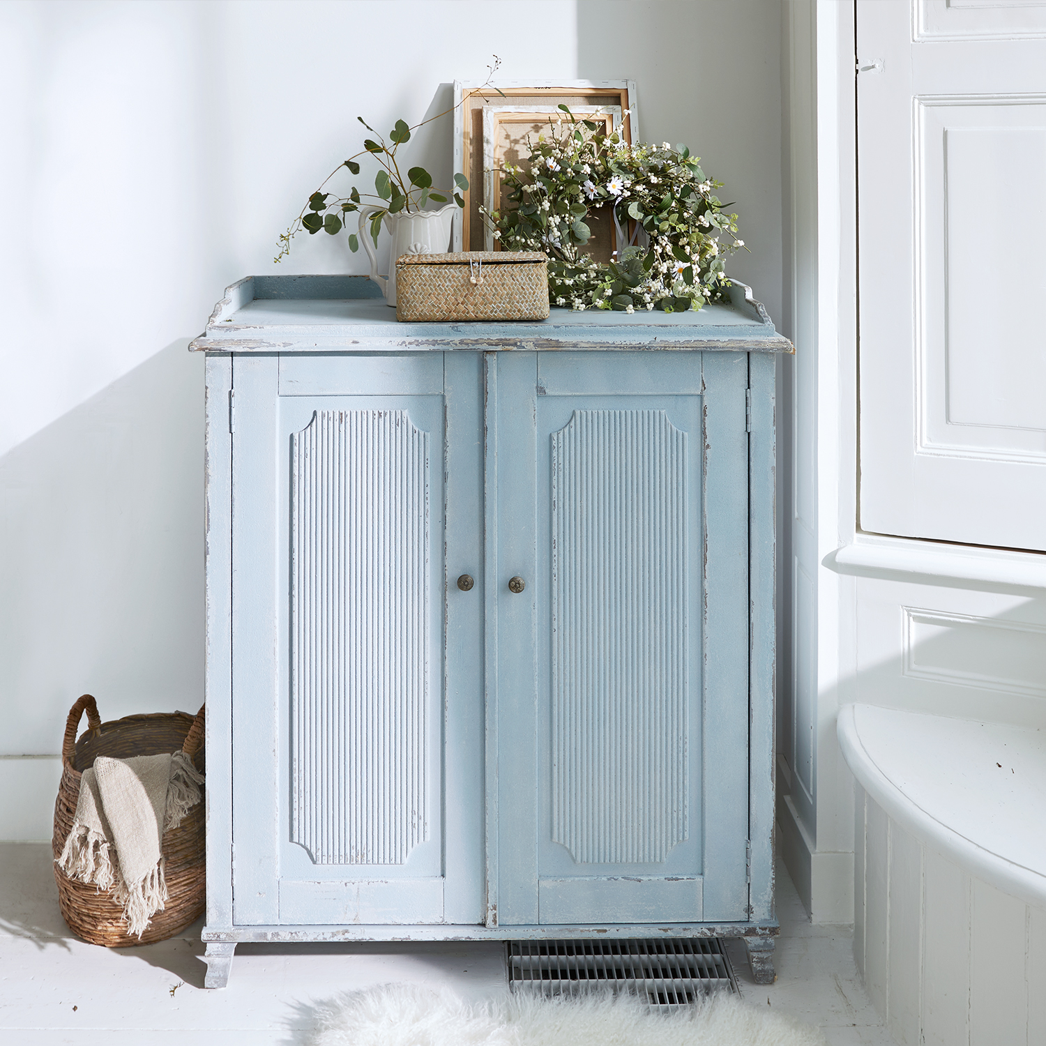 Buffet en bois bleu vieilli avec panneaux décoratifs, meuble vintage pour salon lumineux
