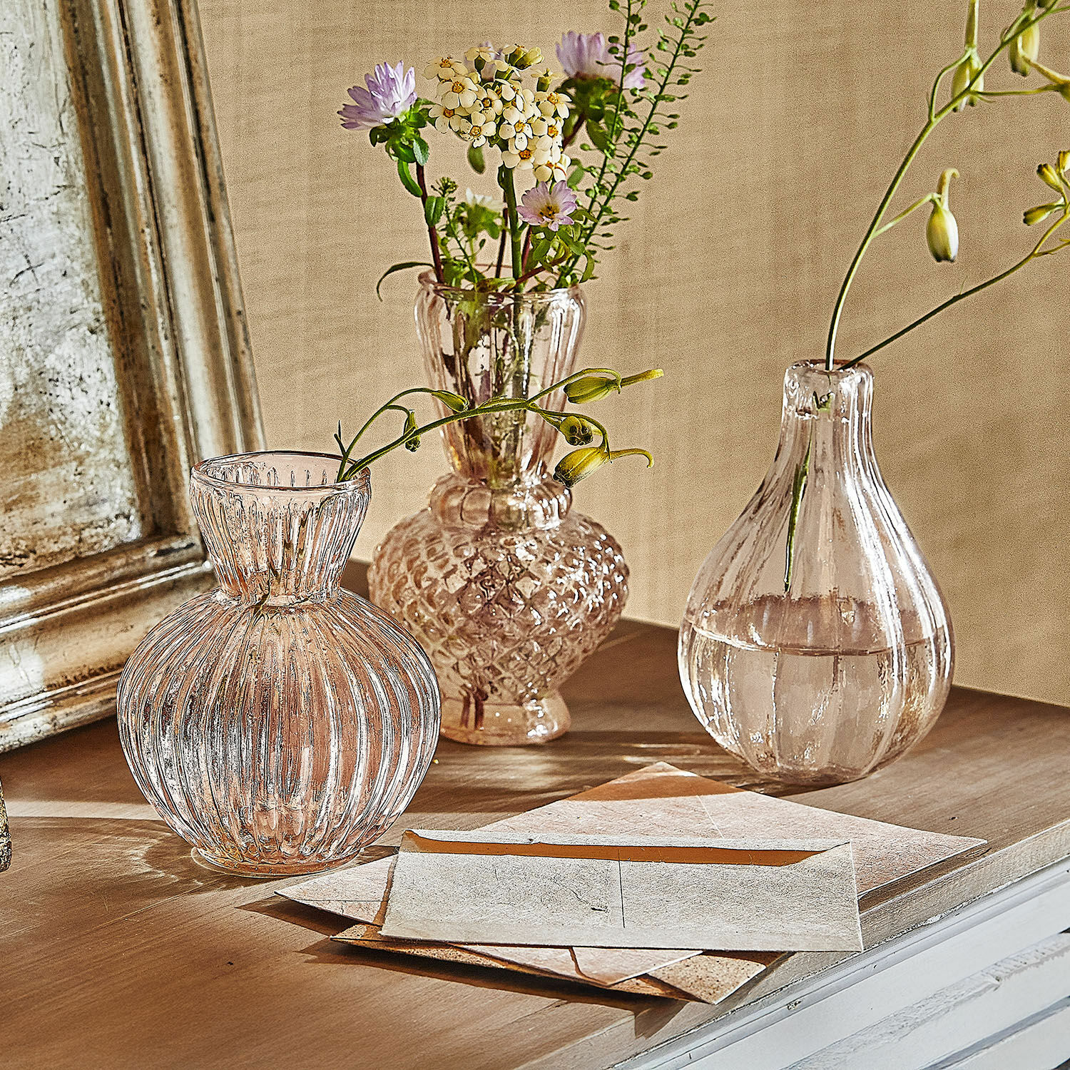 Vaas set van 3 Faunelle Drie transparante glazen vazen met bloemen op een houten tafel in vintage stijl