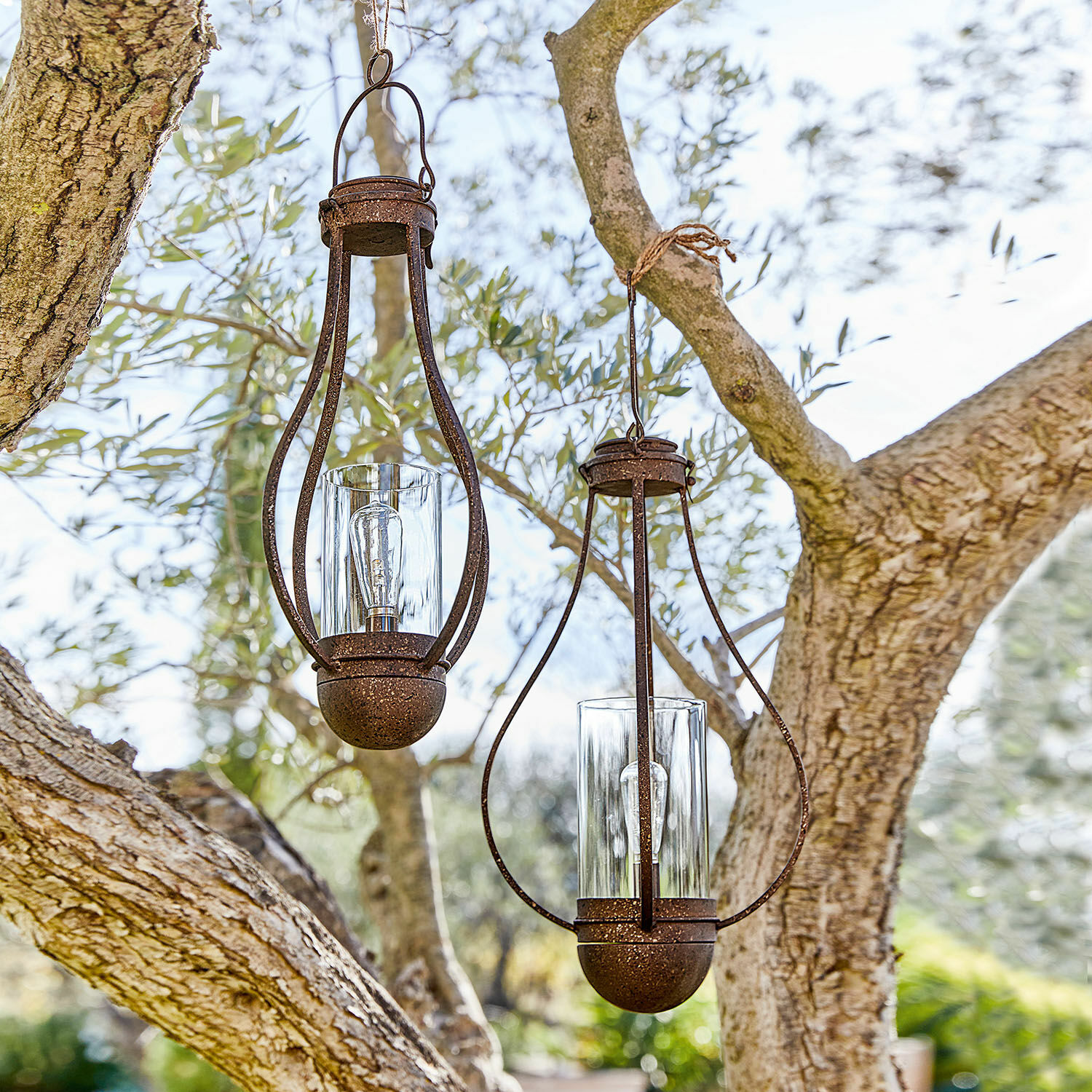Hanglantaarn op zonne-energie set van 2 Marsa Twee hangende lantaarns van roestig metaal met helder glas in een buiten tuin
